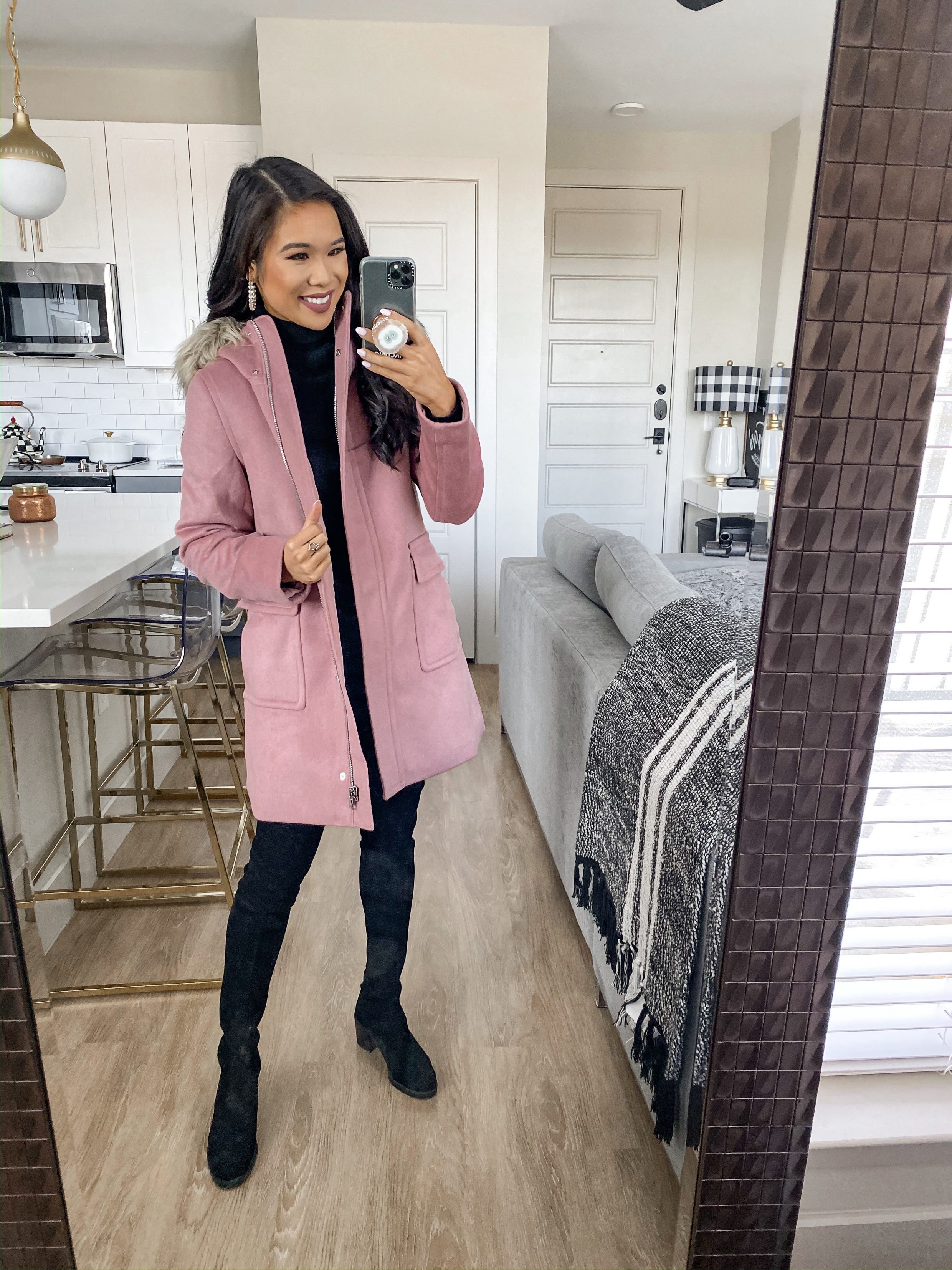 Pink winter coat with faux fur hood over a sleek black look perfect for workwear