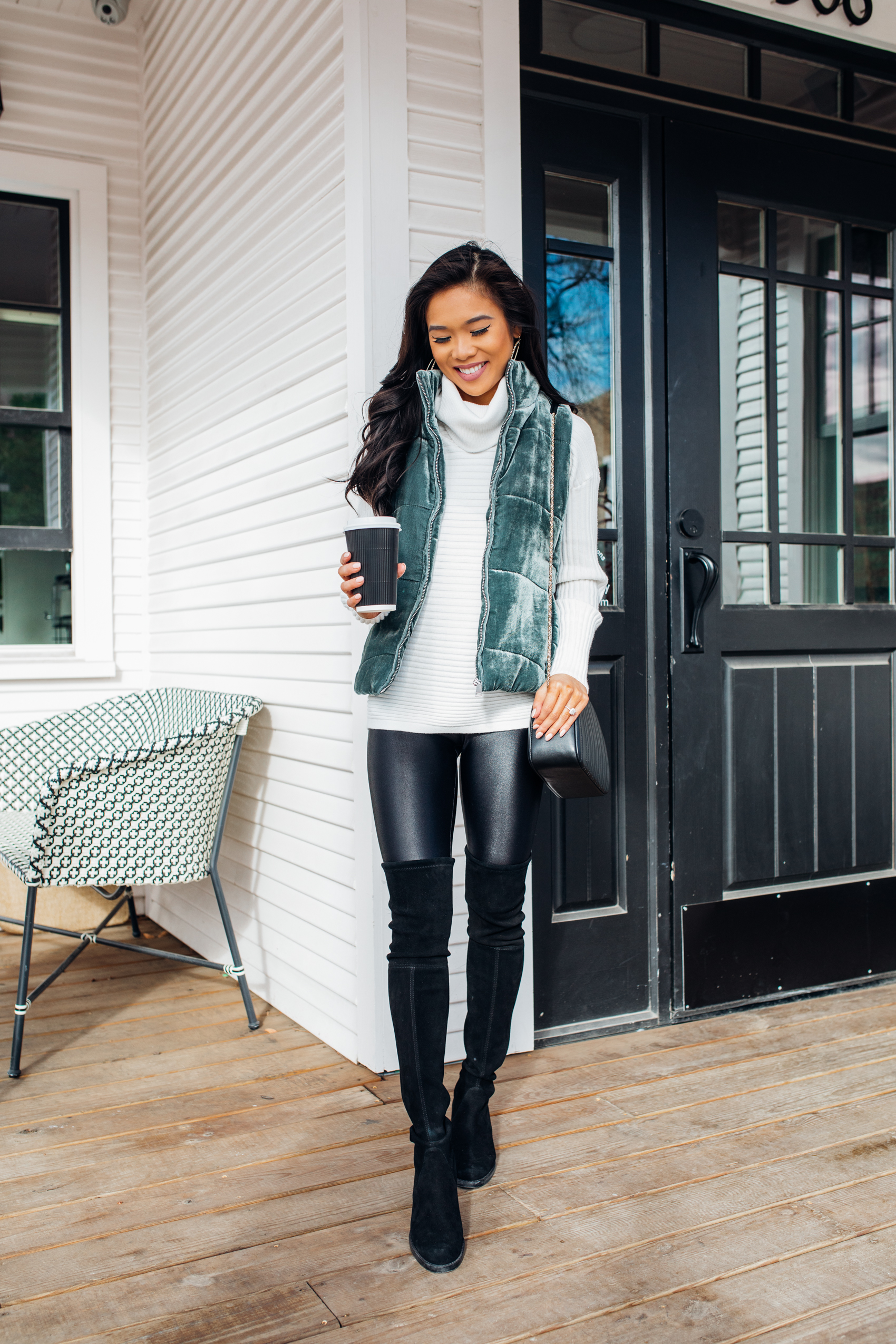 White sweater outfit for winter with a velvet puffer vest, black lustrous leggings, suede over the knee boots on petite blogger