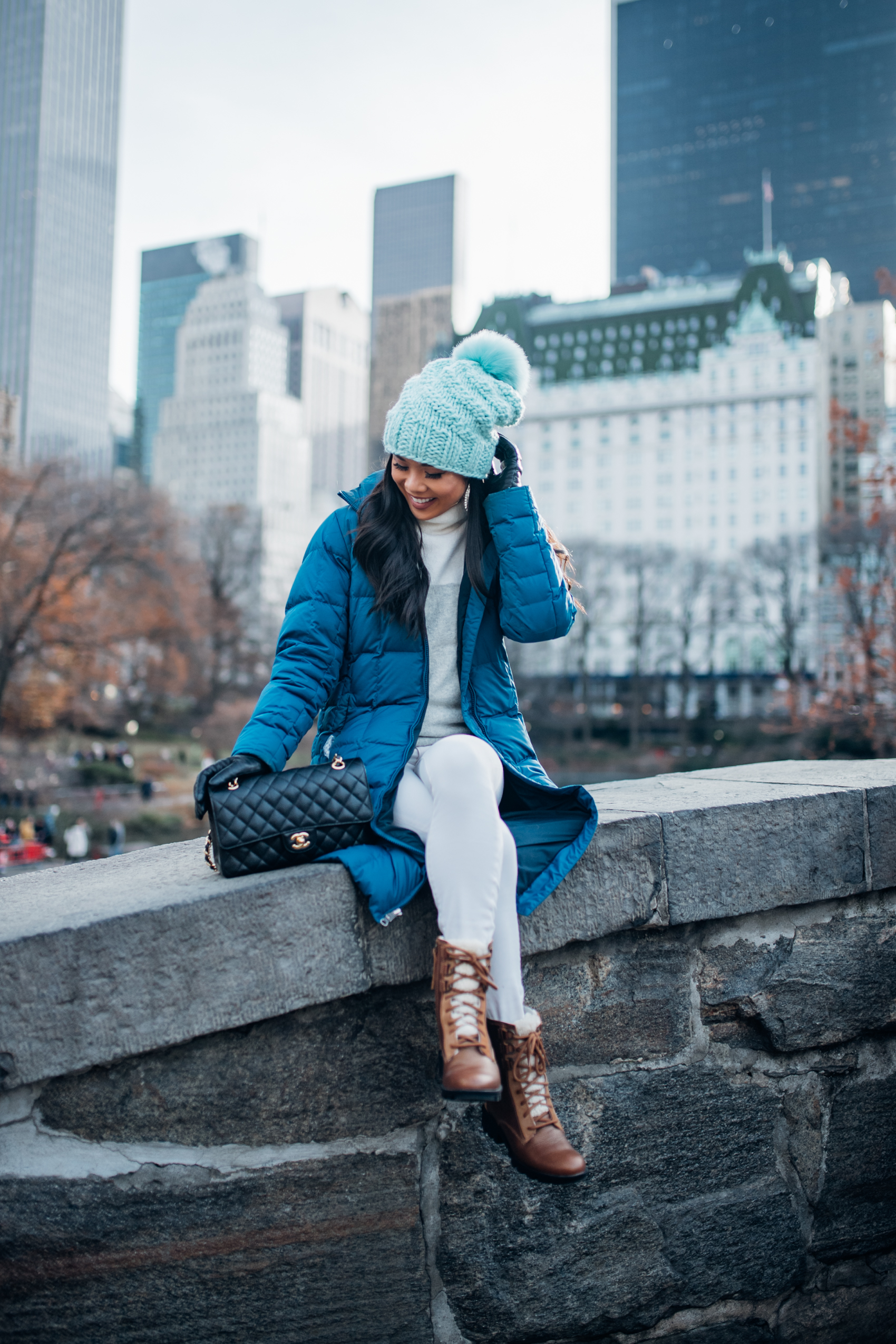 Colorful winter outfit that's actually warm with a blue parka, white colorblock sweater, blue chunky beanie and Chanel double flap bag