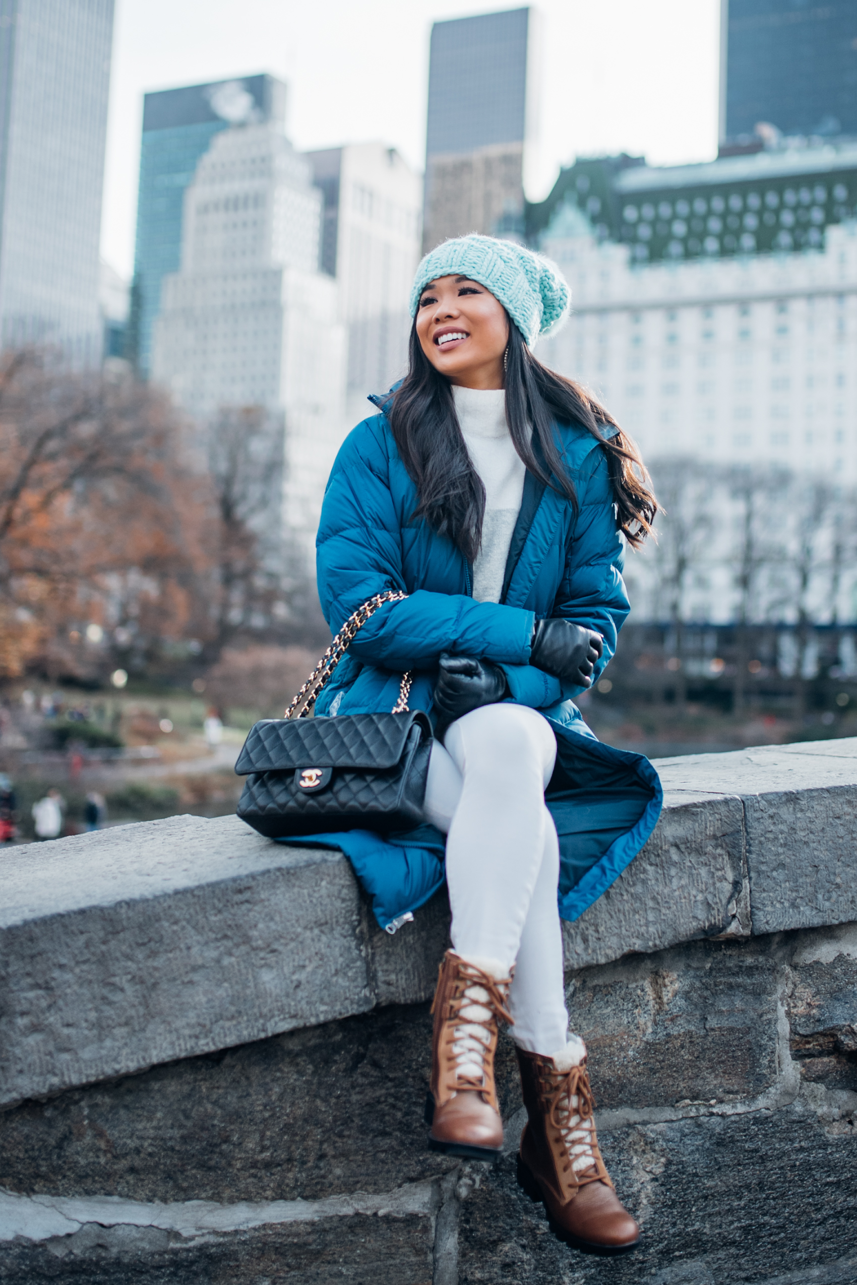 Casual winter outfit with a blue parka, snow boots and Chanel double flap bag in Central Park