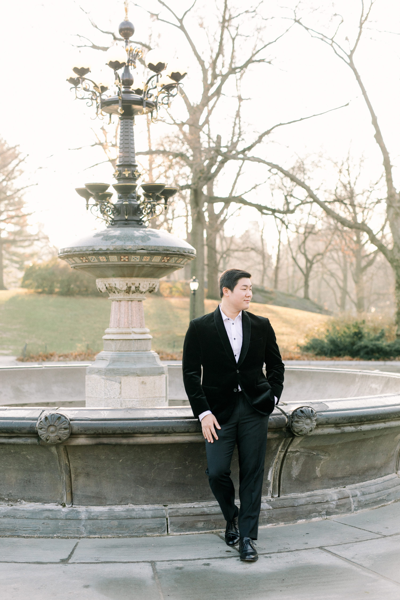 Jonathan Van wearing a black velvet tuxedo for Central Park engagement photos during winter