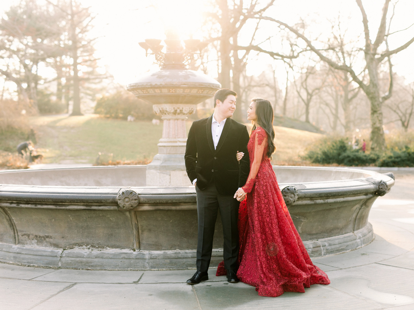 Vietnamese couple winter engagement photos shot in Central Park New York City wearing a red lace ballgown and black velvet tuxedo