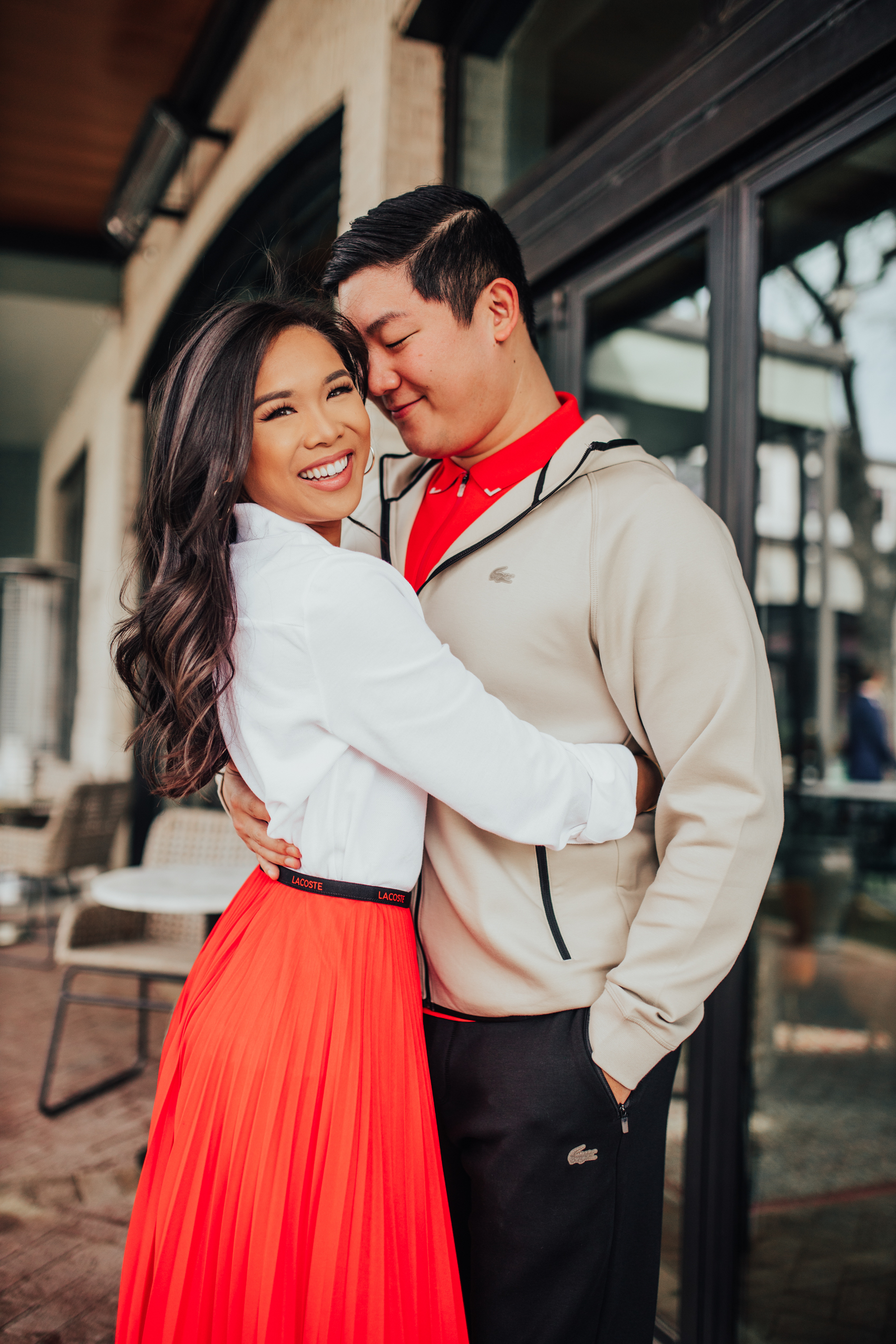 Asian couple wearing a casual spring outfit with an oxford shirt, pleated skirt, hoodie and track pants
