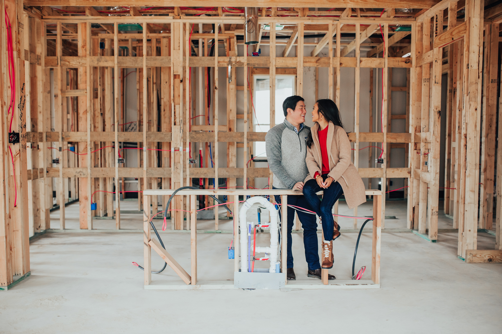 Hoang-Kim and Johnny on their future kitchen island in their one-story new build home before the pre-drywall meeting