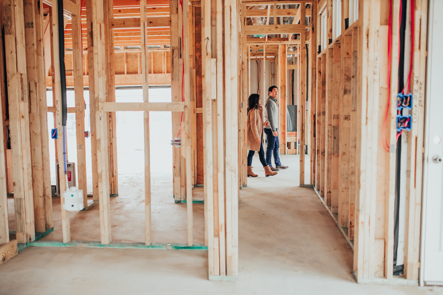 Hoang-Kim and Johnny walk through their one-story house in Dallas after the framing stage before pre-drywall