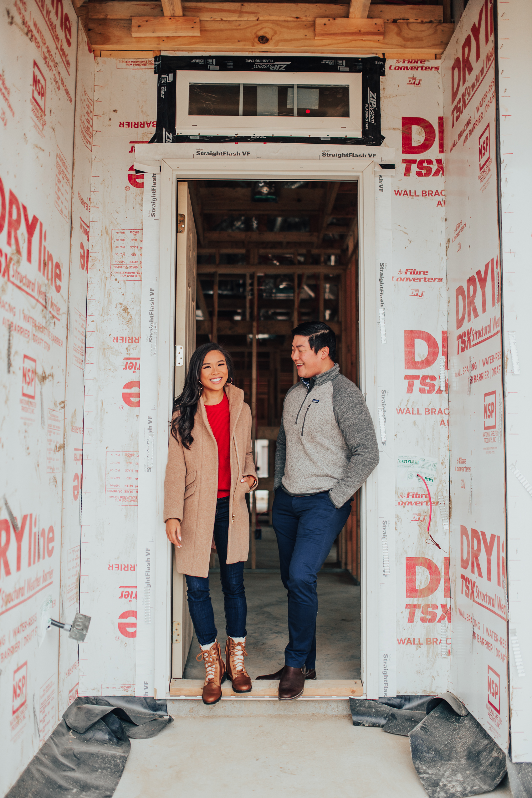 Blogger Hoang-Kim of Color & Chic and her fiance Jonathan Van in the entryway of their one-story three bedroom two bathroom house in Dallas during the pre-drywall phase