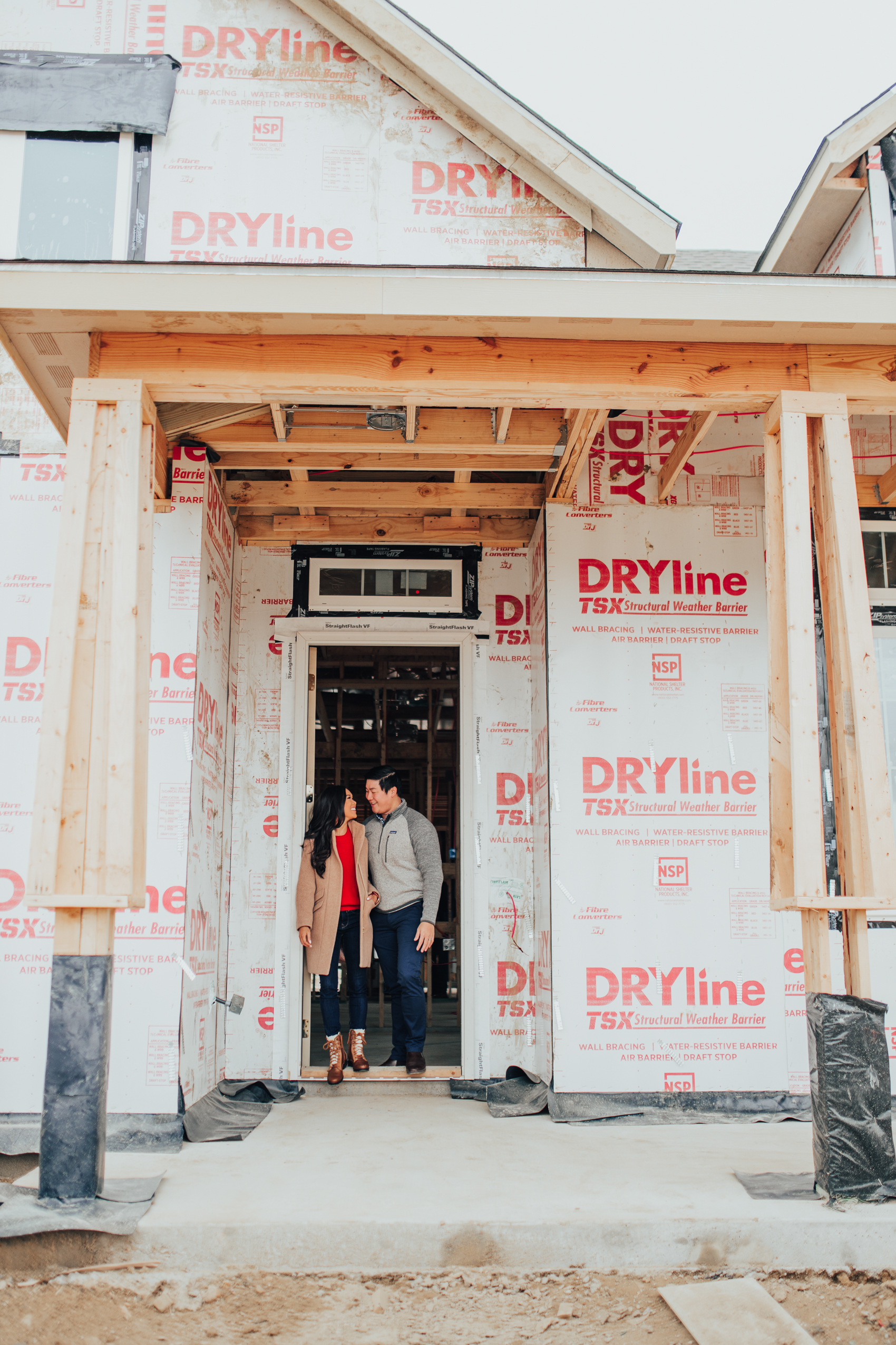 Blogger Hoang-Kim of Color & Chic and her fiance Jonathan Van in front of their one-story Dallas house after the framing process