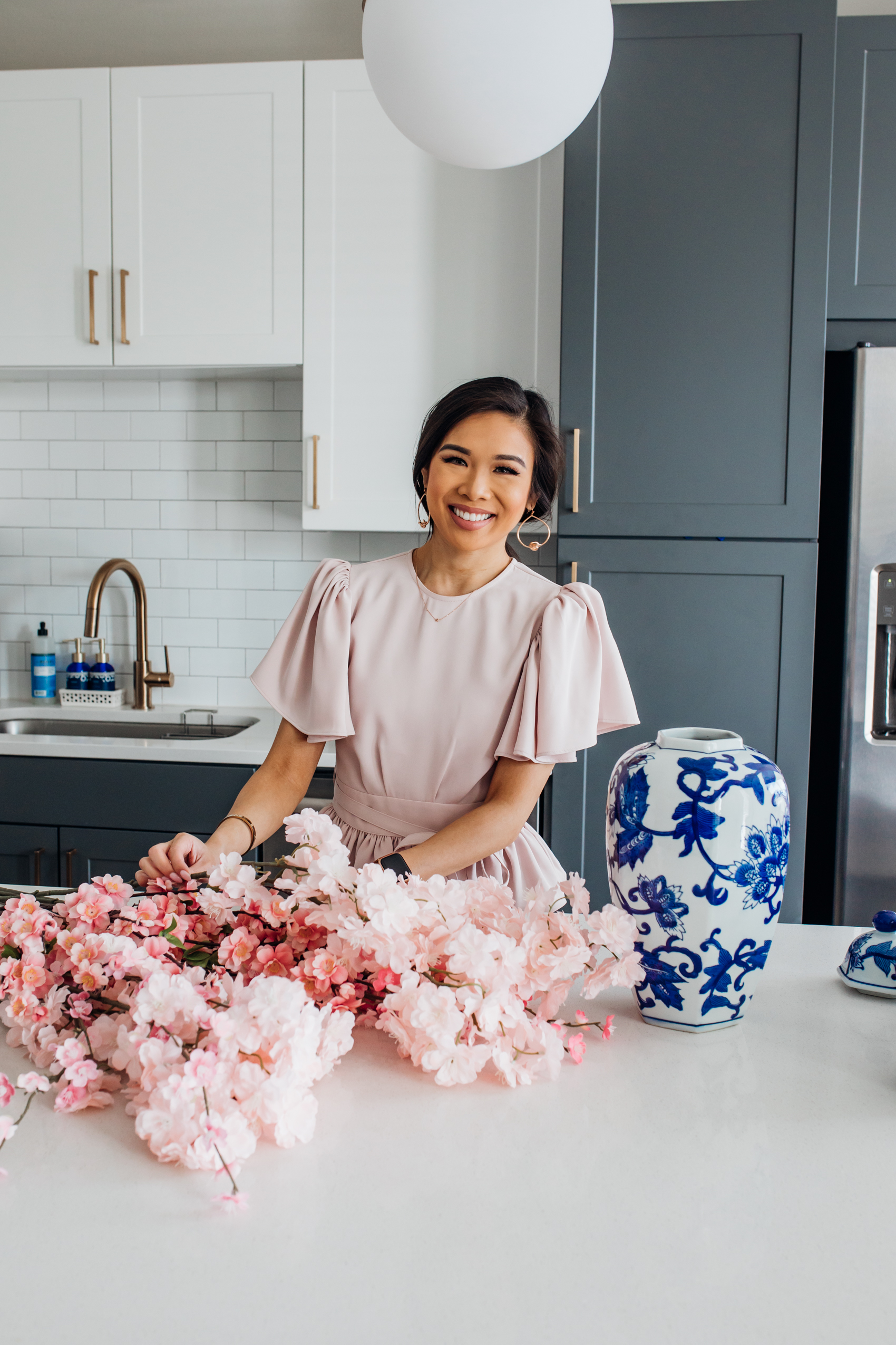 Blogger Hoang-Kim shares how she refreshes her two-toned kitchen with spring home decor using a ginger jar, cherry blossoms and candles