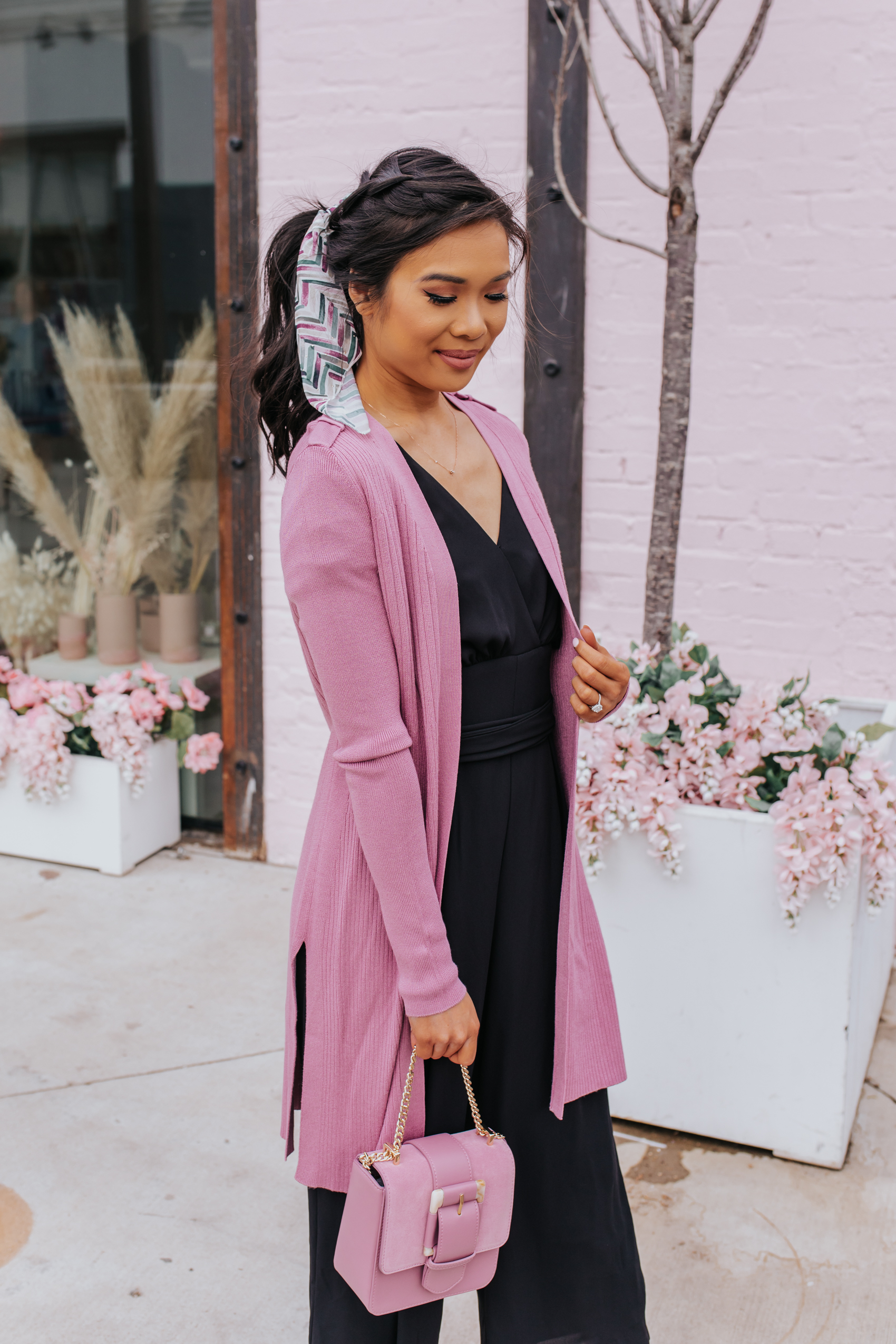 Braided hairstyles for spring with a loose dutch braid by Tousled Studio, black jumpsuit, pink cardigan, pink clutch on petite Dallas Blogger Hoang-Kim