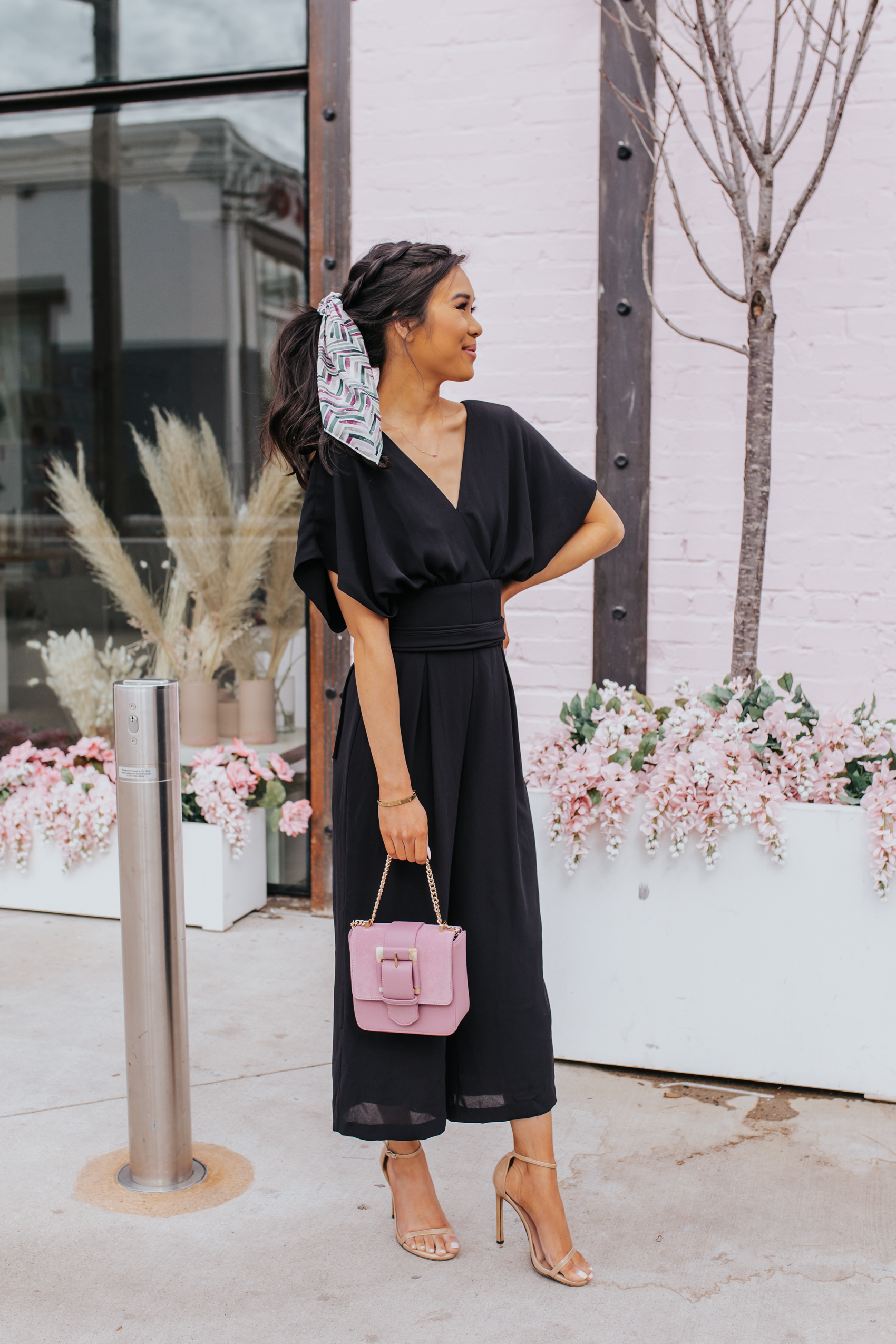 Black wide-leg jumpsuit, chevron hair scarf with a braided hairstyle by Tousled Studio, pink clutch and heeled sandals for spring outfits