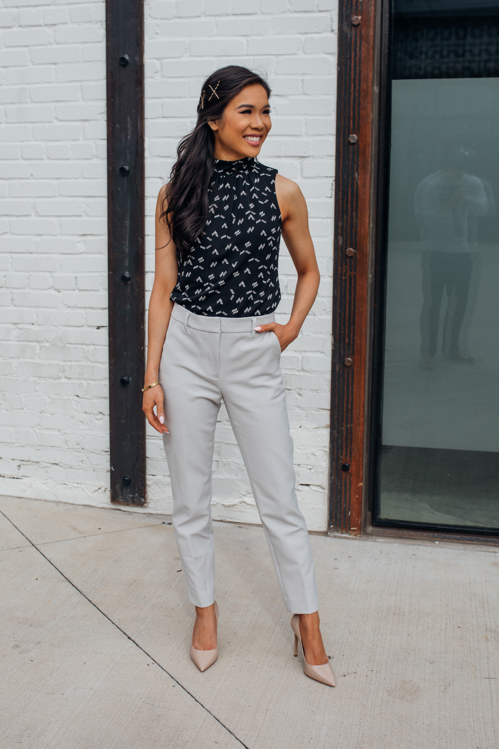 Blogger Hoang-Kim wears light gray comfort stretch slim pants in light gray, chevron mock neck shell and M.Gemi nude heels with a half-up half down hairstyle for spring workwear