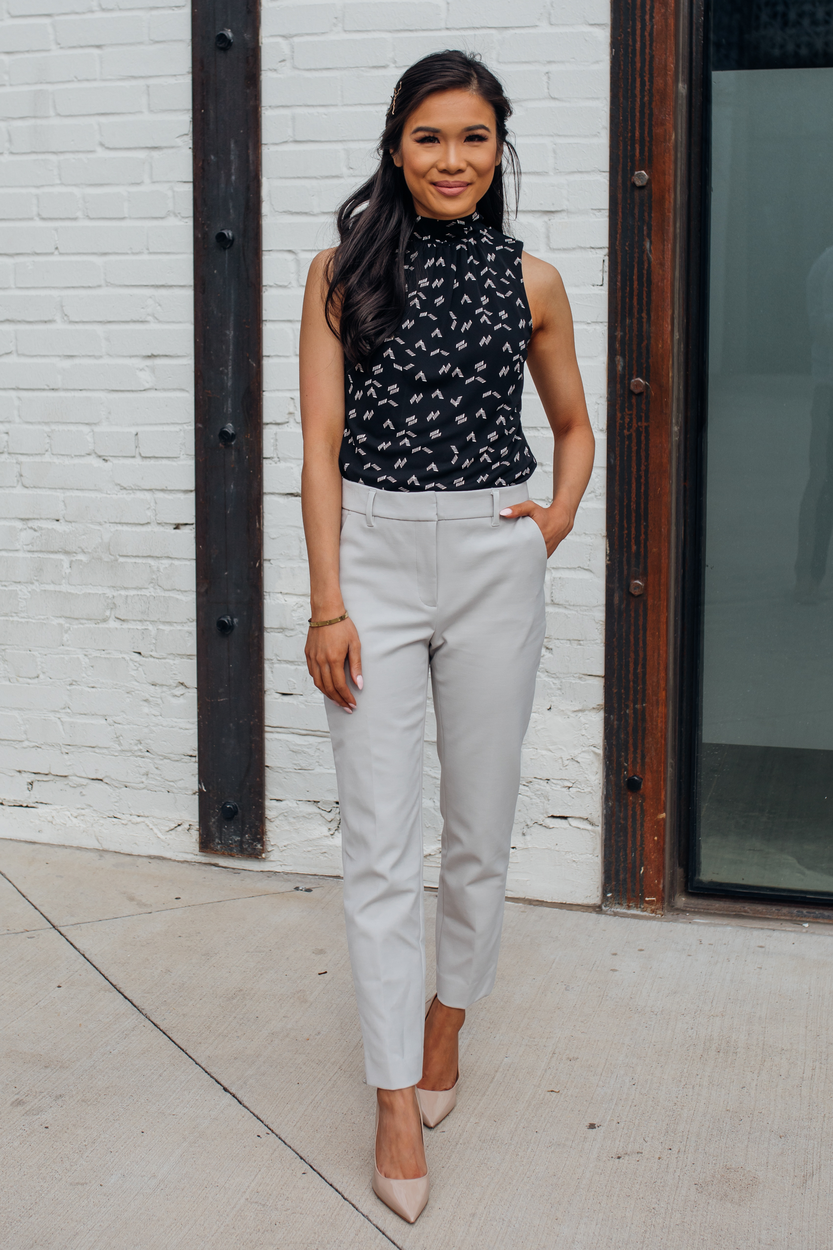 Blogger Hoang-Kim wears light gray comfort stretch slim pants in light gray, chevron mock neck shell and M.Gemi nude heels with a half-up half down hairstyle for spring workwear