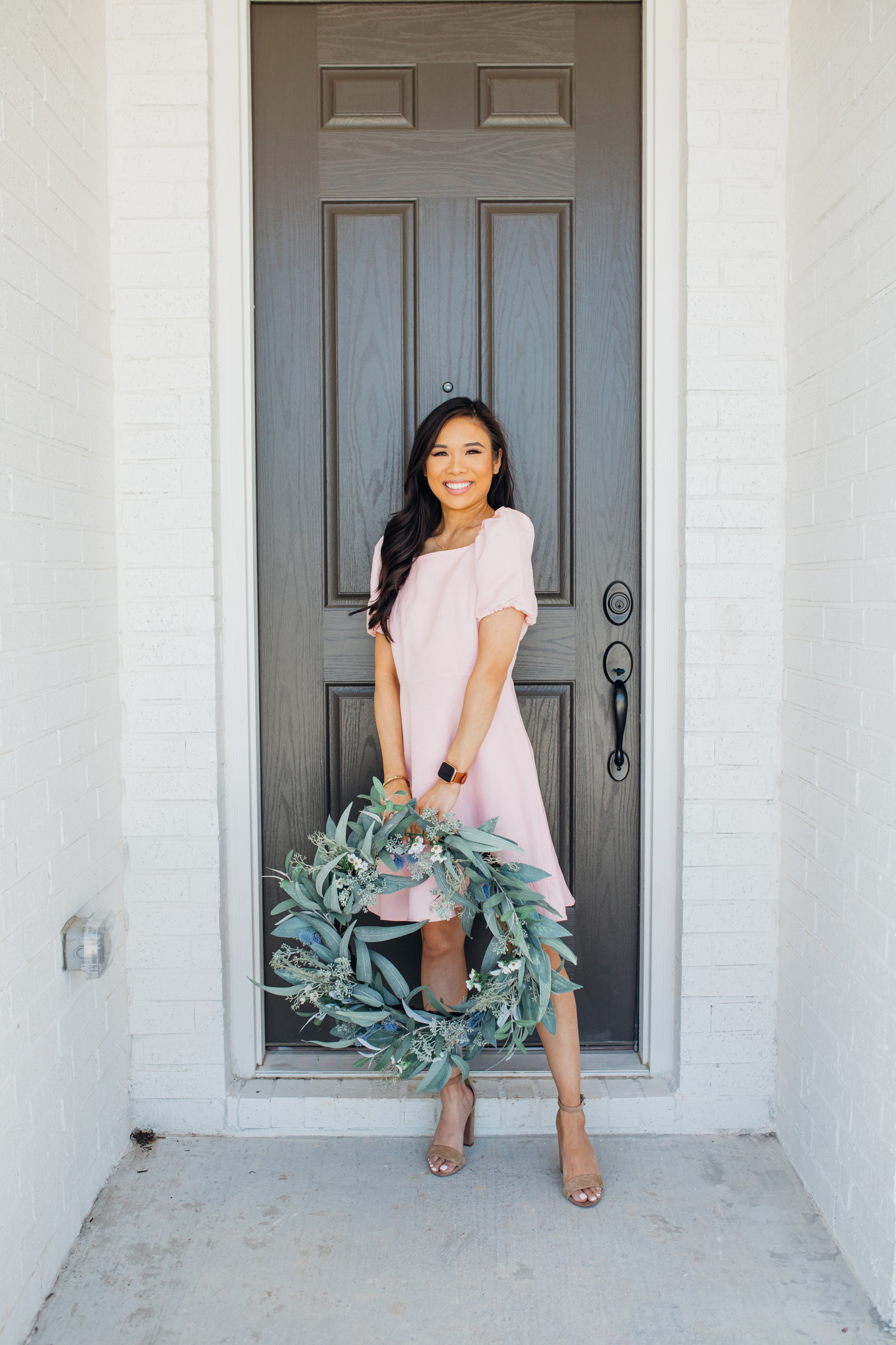 Blogger Hoang-Kim wearing a pink puff sleeve linen dress with a faux eucalyptus wreath 
