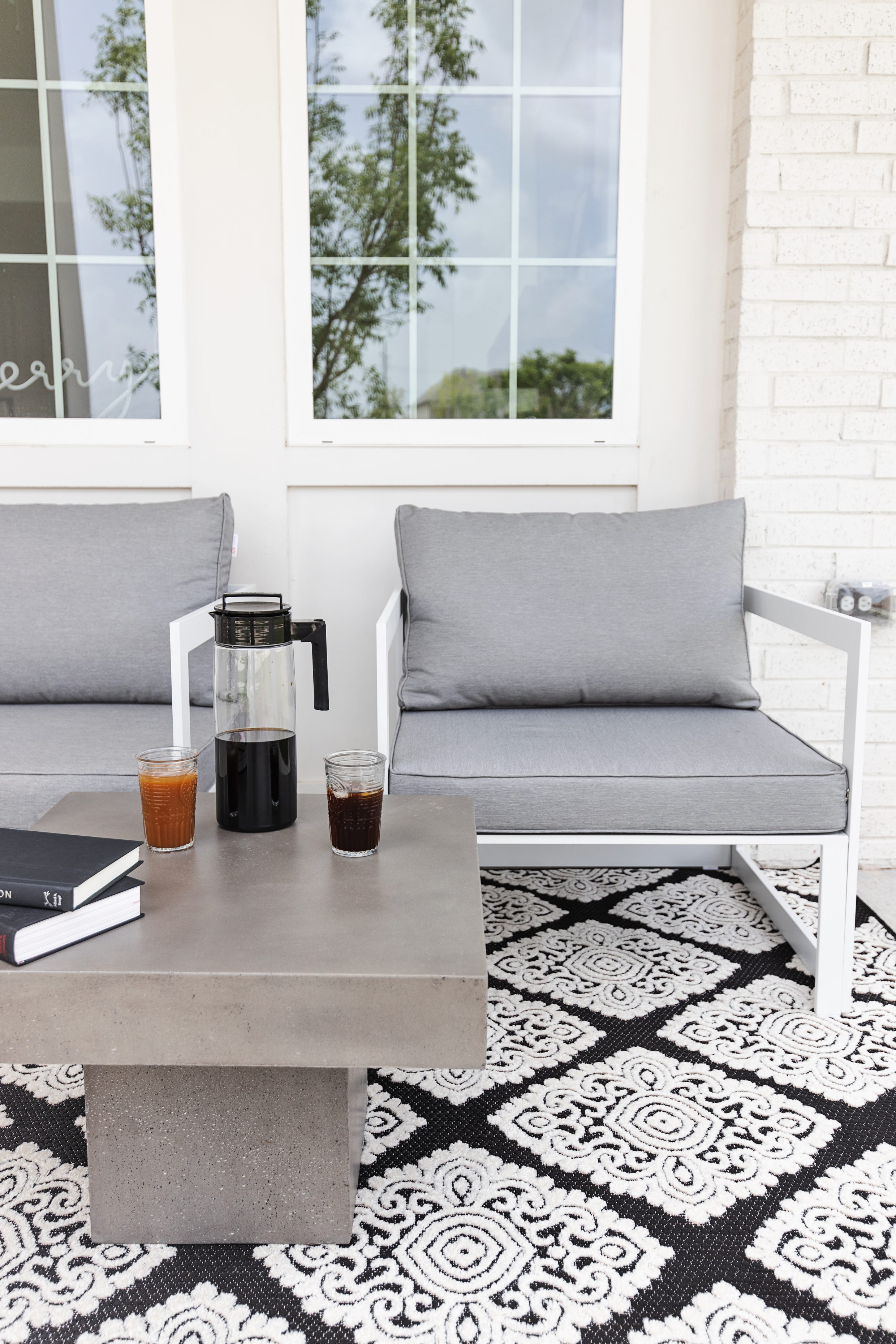 Modern Outdoor Patio furniture from Bed Bath and Beyond with concrete coffee table and black and white rug