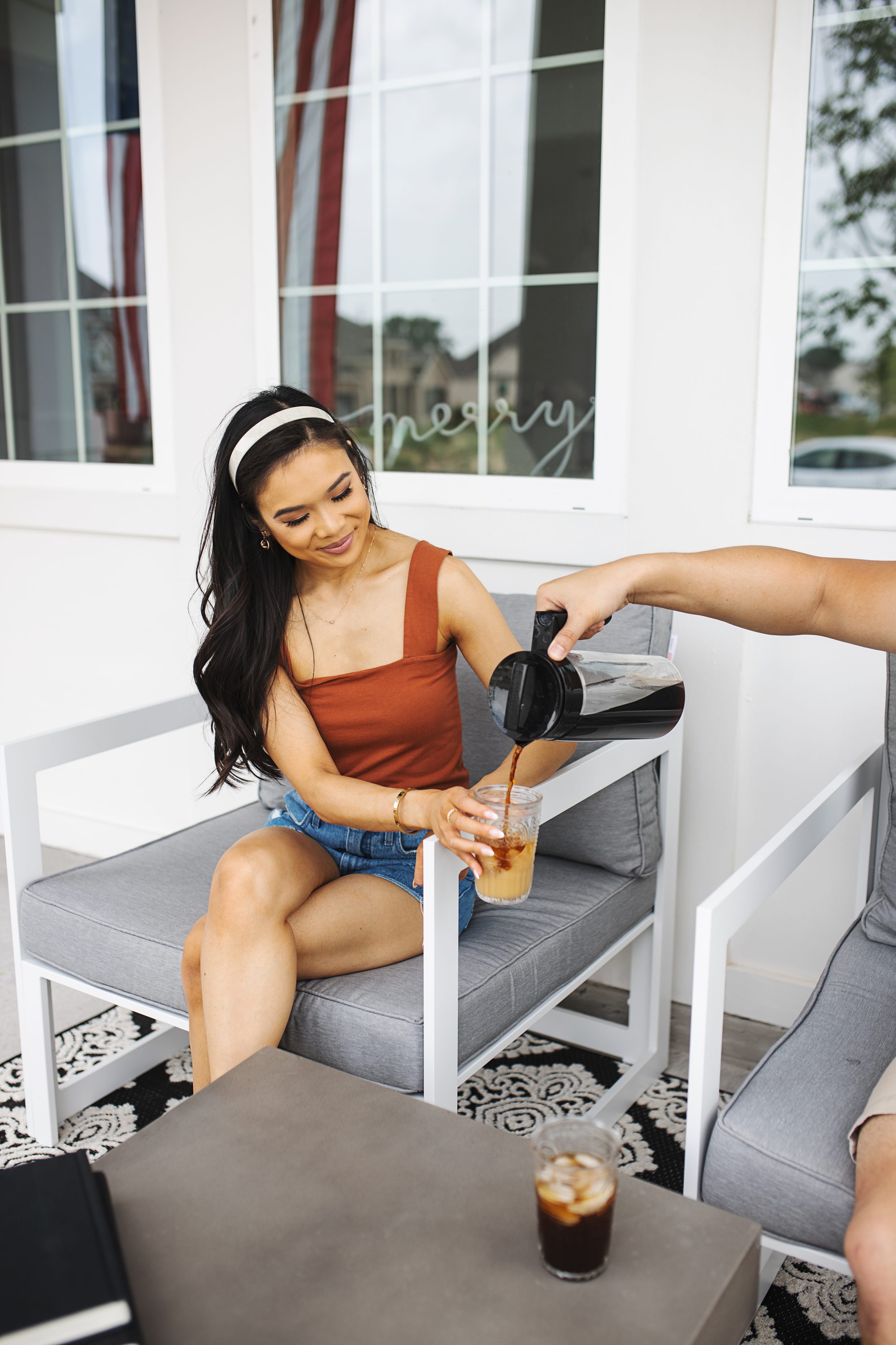 Blogger Hoang-Kim enjoying freshly made cold brew from her Takeya cold brew maker on her outdoor furniture