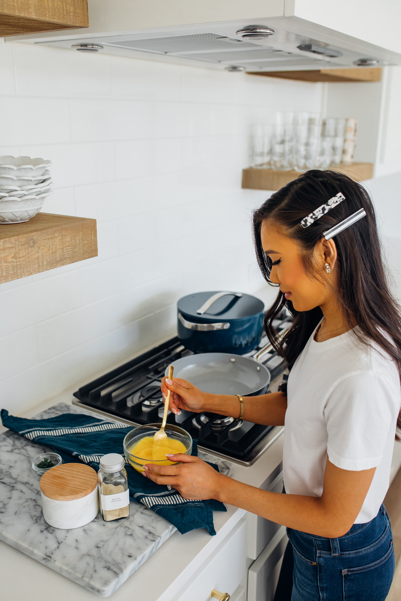 Caraway Cookware, a ceramic coated nontoxic cookware company, in a white kitchen with gas cooktop