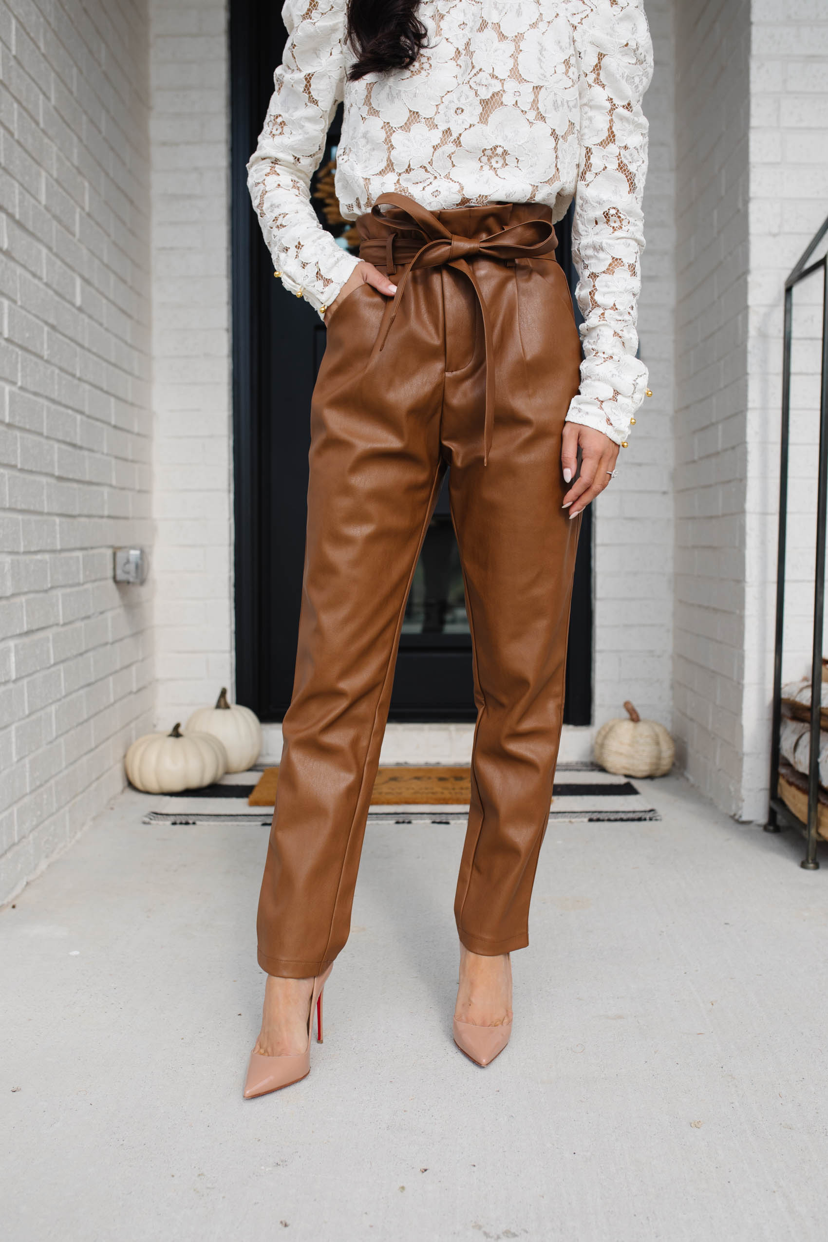 Blogger Hoang-Kim wears tie-waist leather pants with a lace blouse for a fall workwear outfit