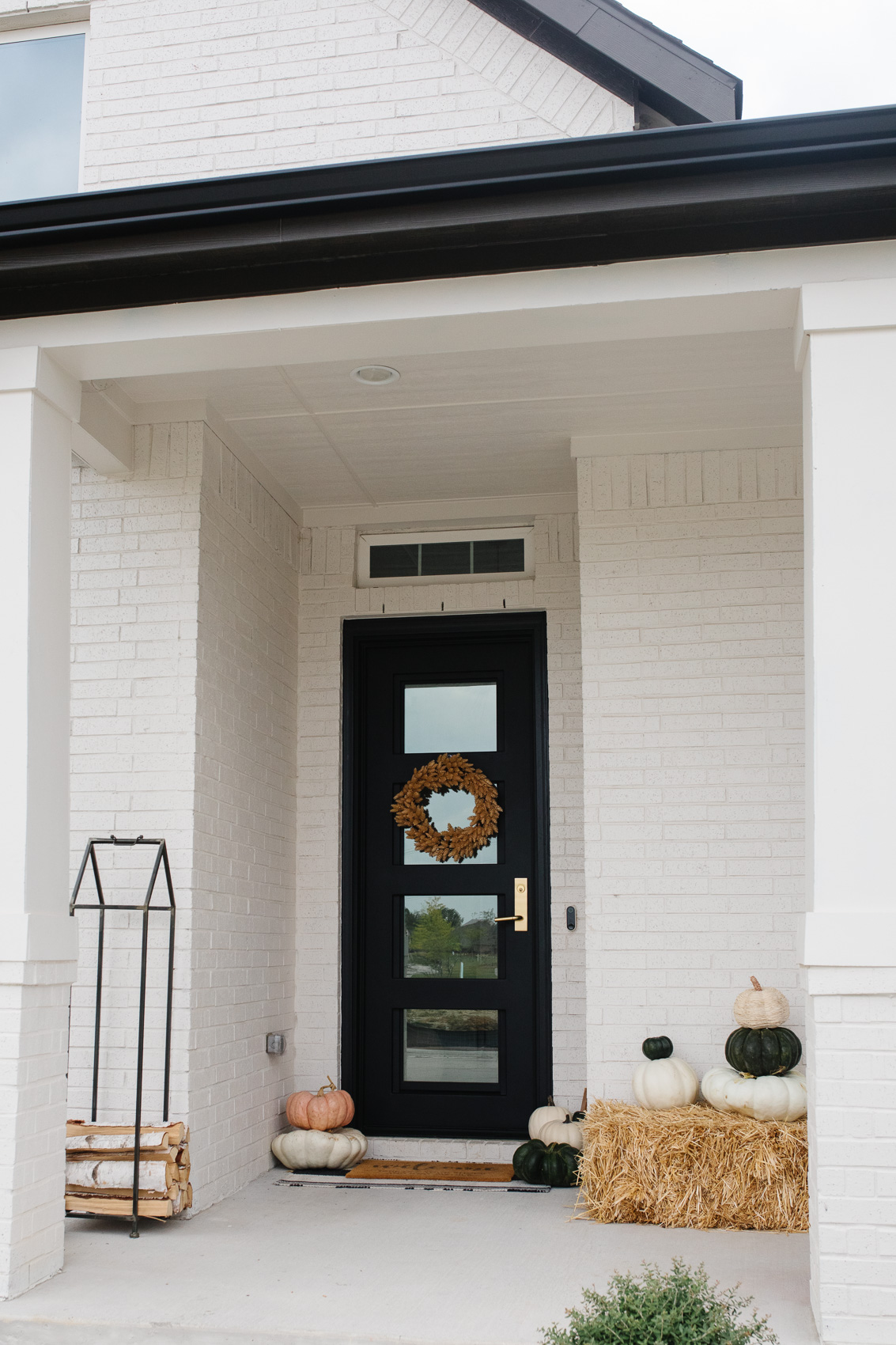 Fall front porch decor on a white painted brick house with Pinkys Iron Doors Air 19