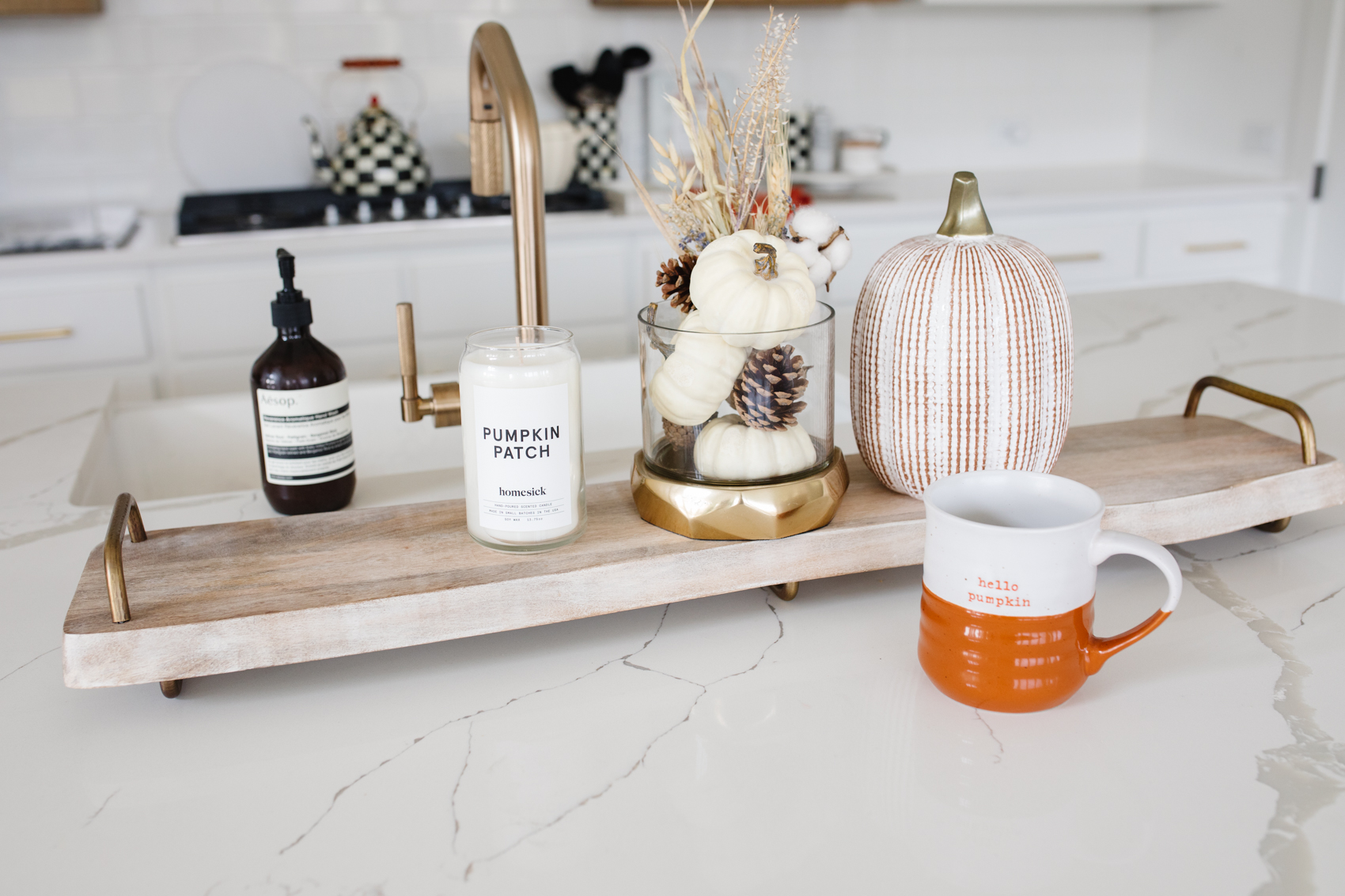 Kitchen fall decor with Aesop reverence soap, white ceramic pumpkins, pumpkin patch candle, cheeseboard and MacKenzie-Childs items