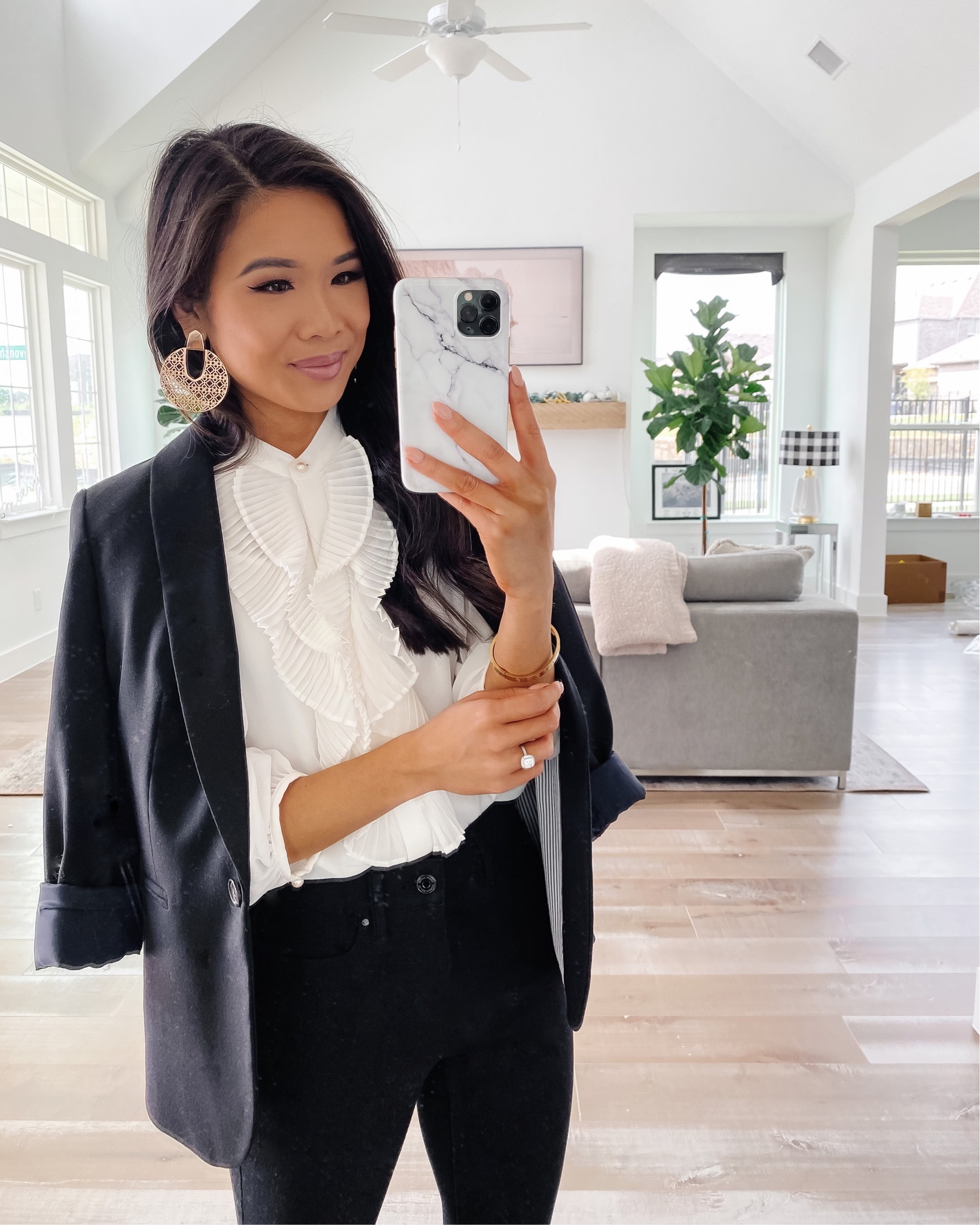 Blogger Hoang-Kim shares a business casual outfit with a black wool blazer, white pleated top and black high waisted jeans 