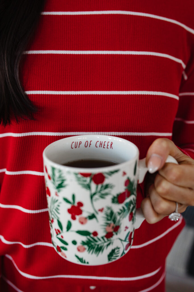 blogger hoang-kim cung holding a target christmas mug that says "cup of cheer"