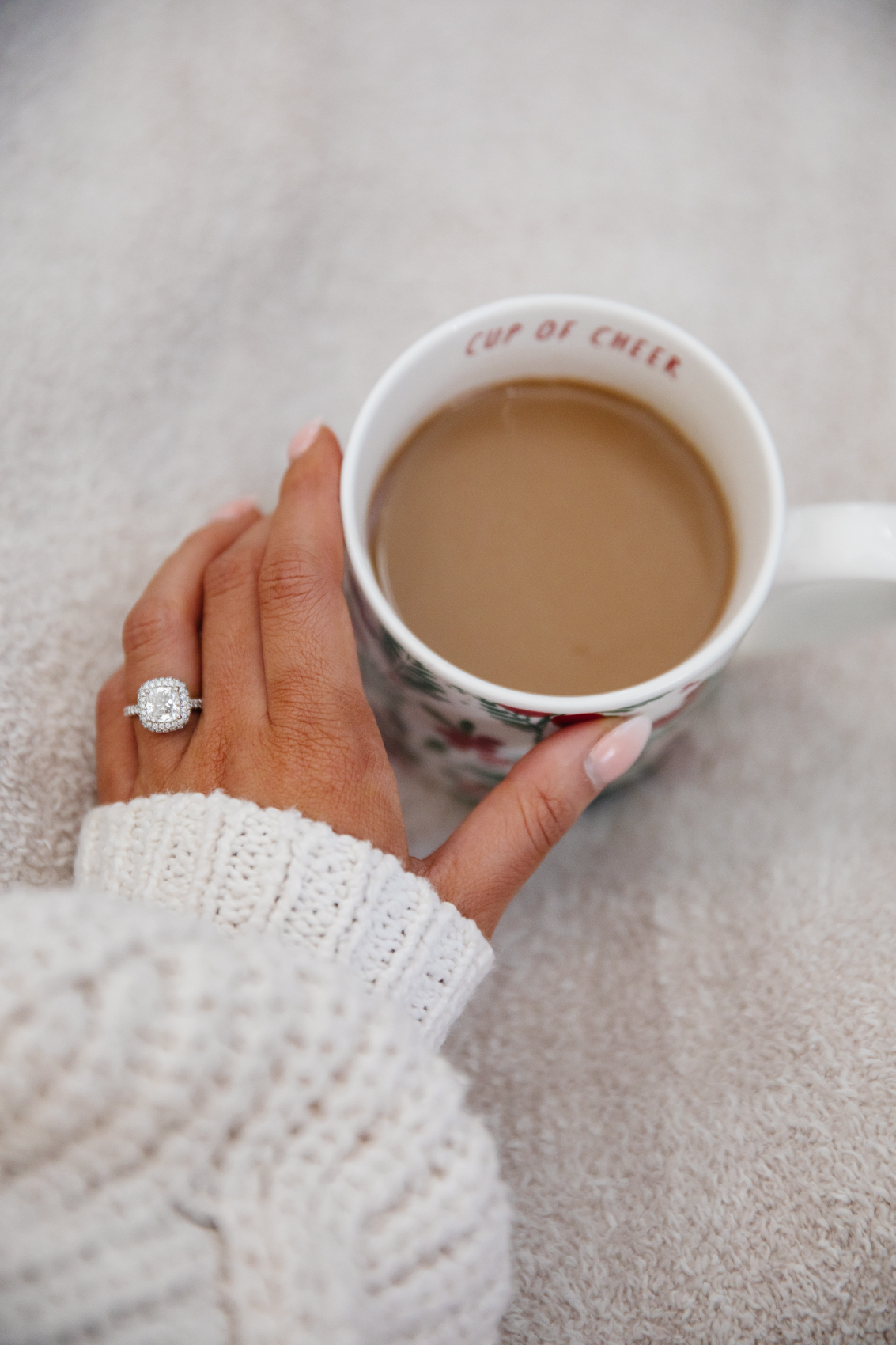 Cushion cut diamond engagement ring with a cup of coffee by James Allen