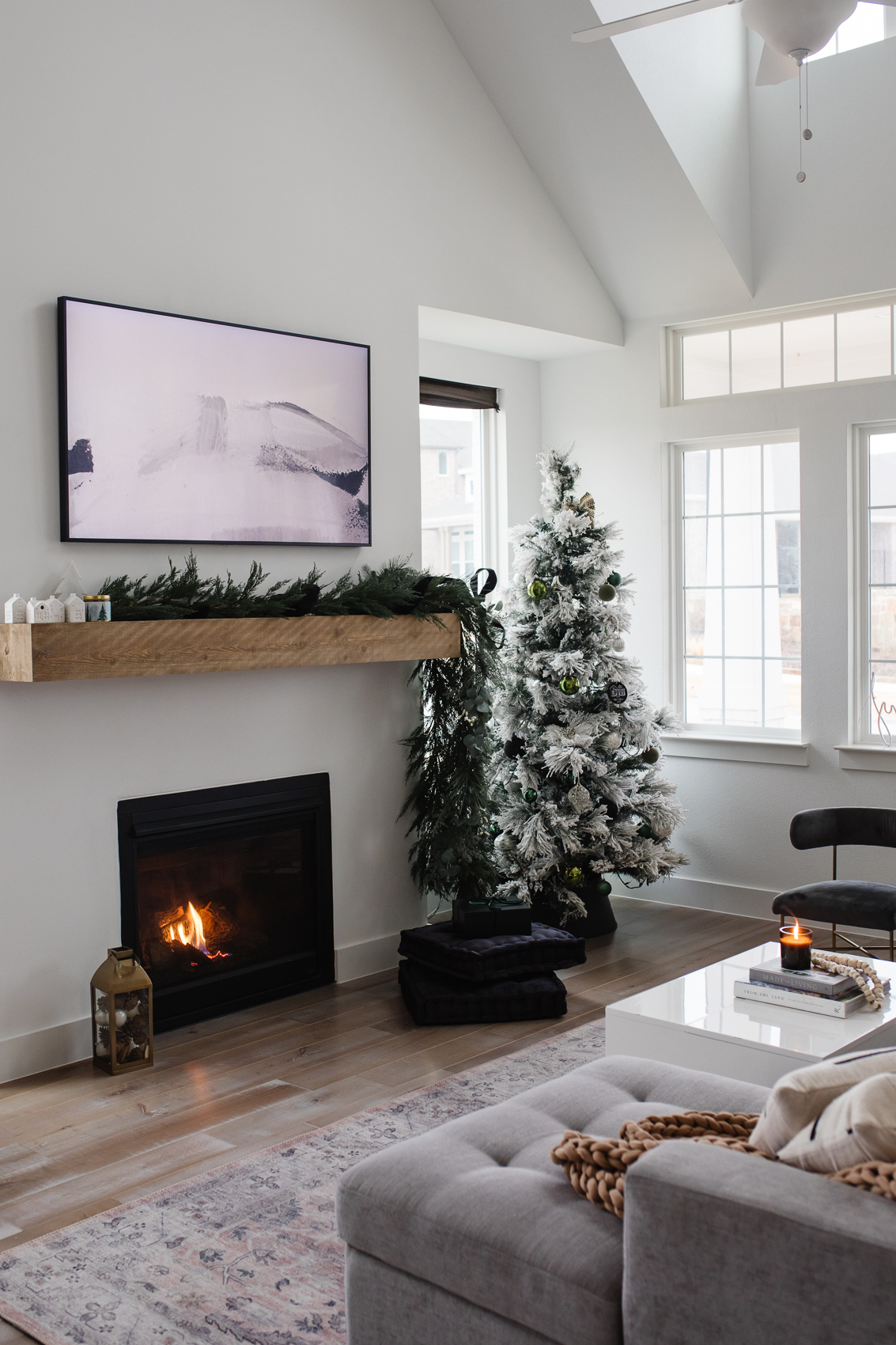 Samsung Frame TV in living room with vaulted ceilings, mantle and modern Christmas decor