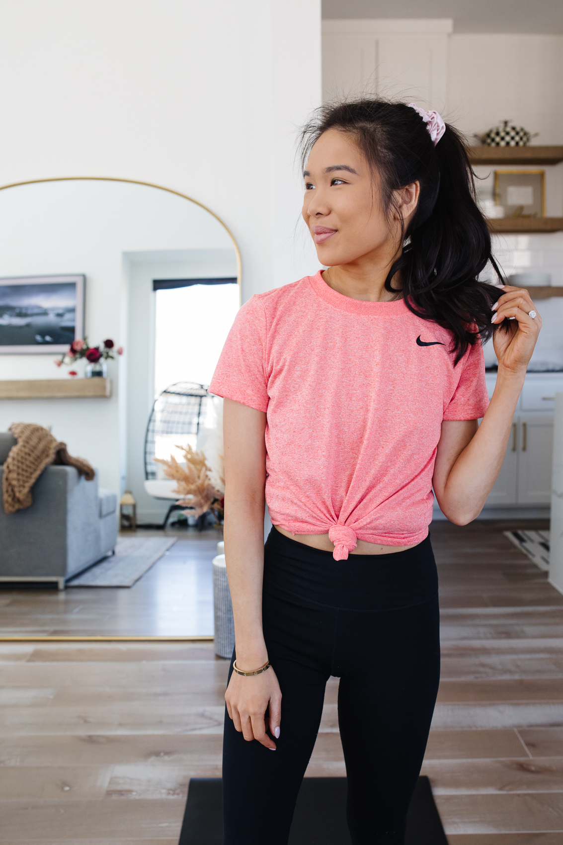 Blogger Hoang-Kim wearing Nike One Lux leggings, dri-fit t-shirt and Nike renew sneakers for an at home workout in her Dallas home