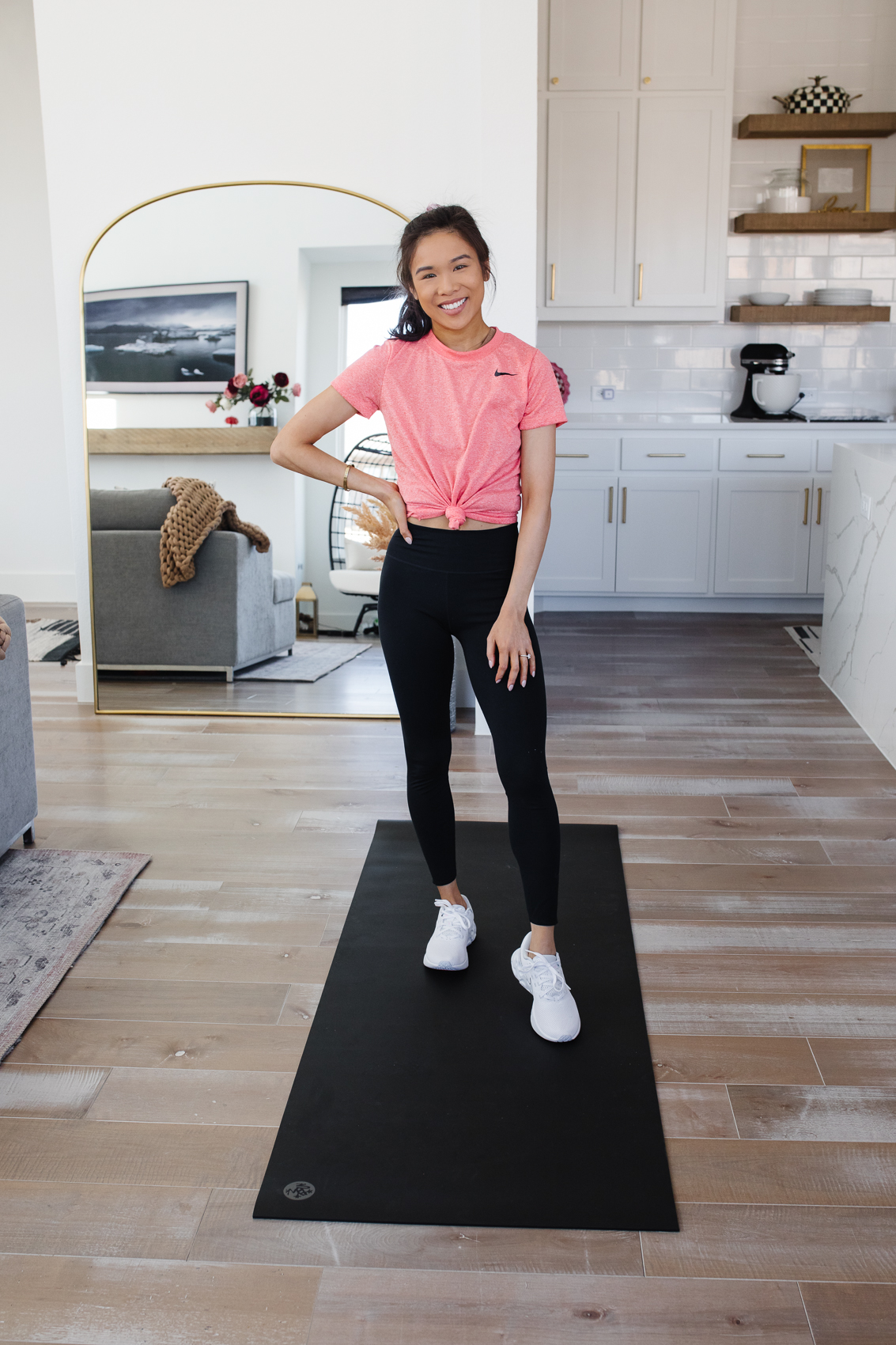 Blogger Hoang-Kim wearing Nike One Lux leggings, dri-fit t-shirt and Nike renew sneakers for an at home workout in her Dallas home