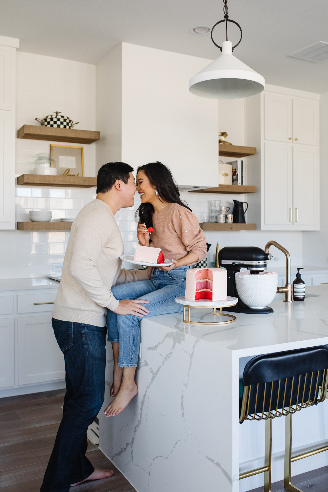 Blogger Hoang-Kim and her fiance Johnny enjoy a slice of ombre cake in their white transitional kitchen with a waterfall island