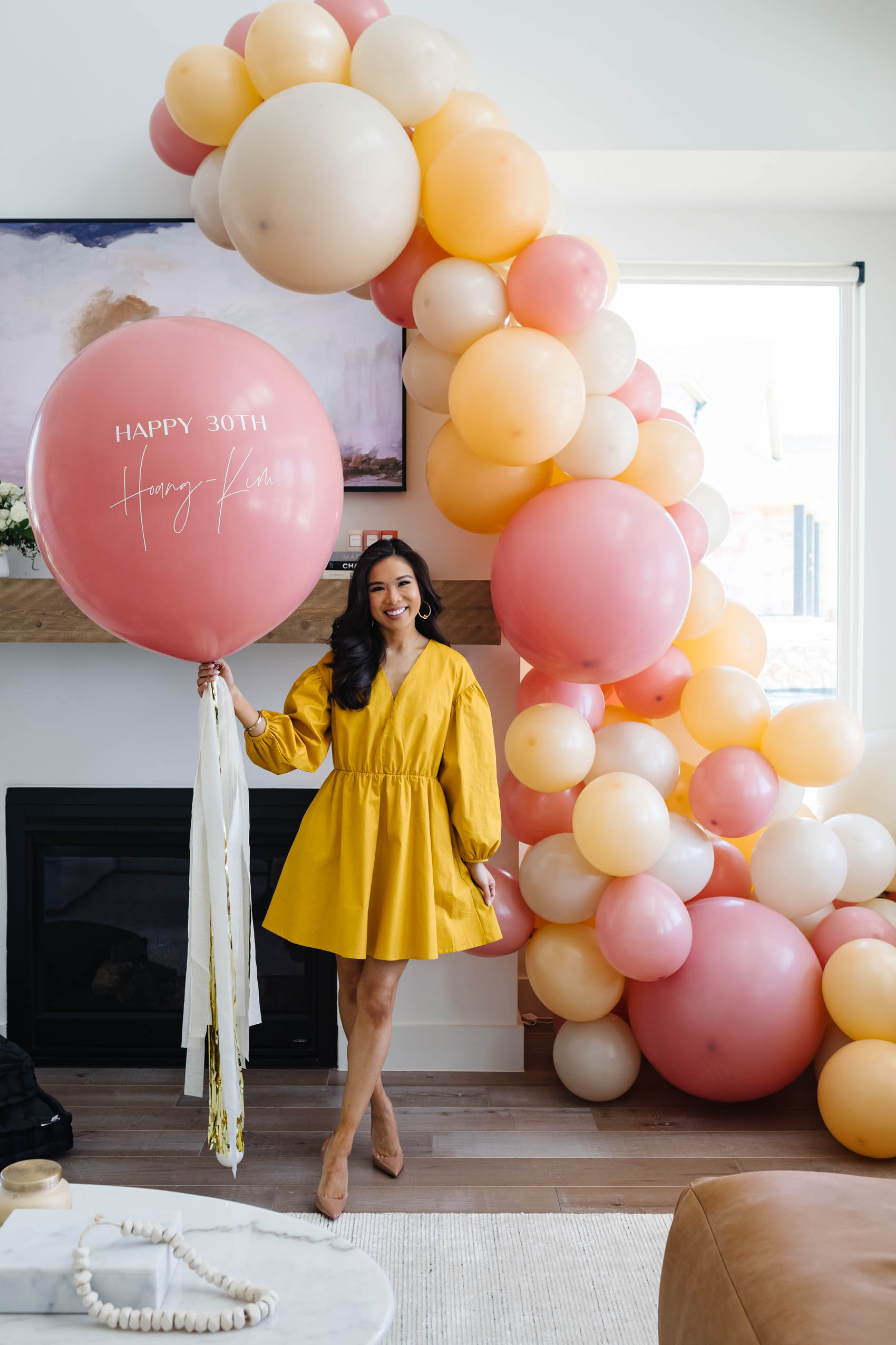 Blogger Hoang-Kim celebrates her 30th Birthday Party at Home with a balloon garland from Lushra and custom jumbo balloon wearing a yellow dress in her Dallas home
