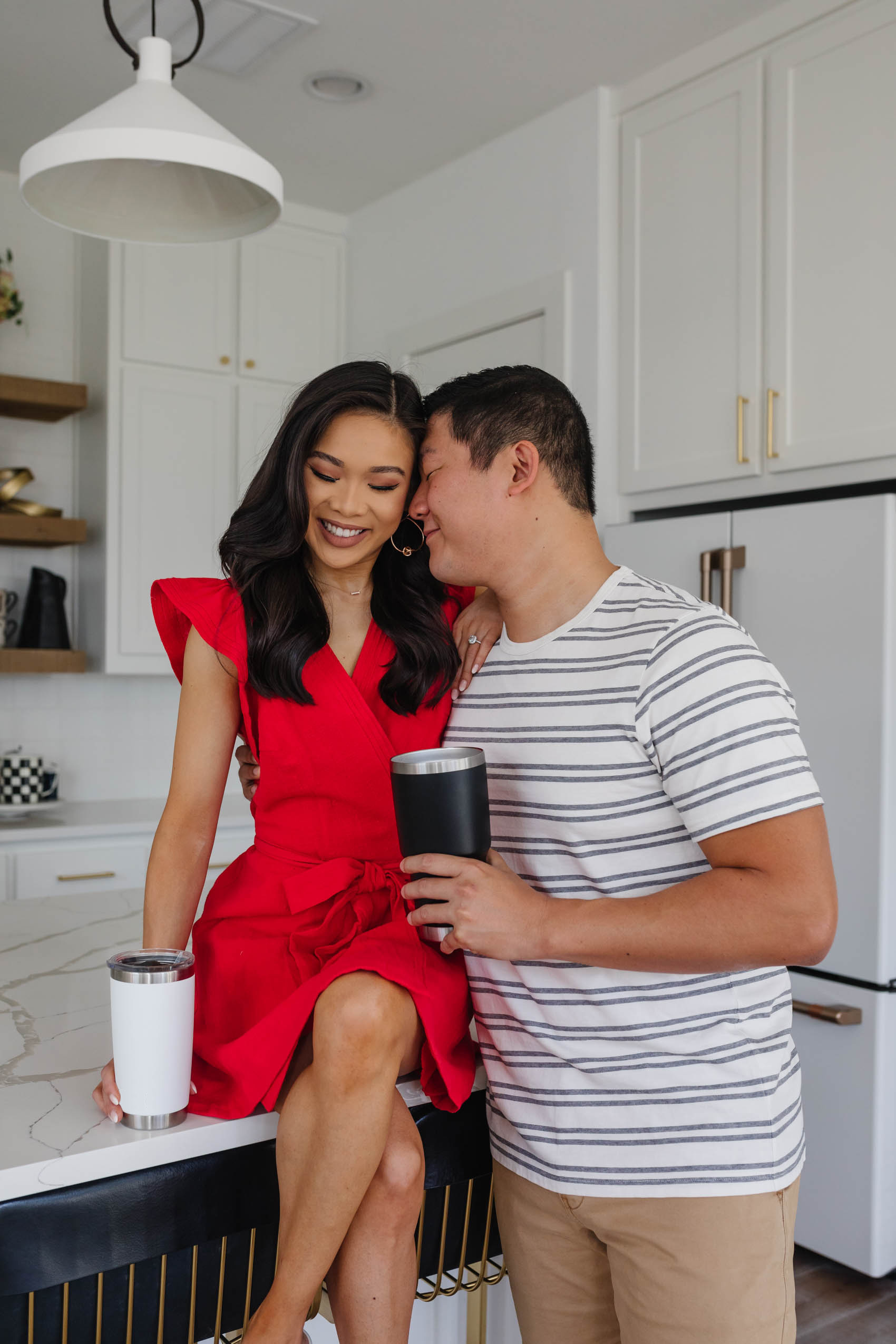 Blogger Hoang-Kim wears a red wrap dress from Madewell while her Fiance Johnny wears a striped tee and shorts