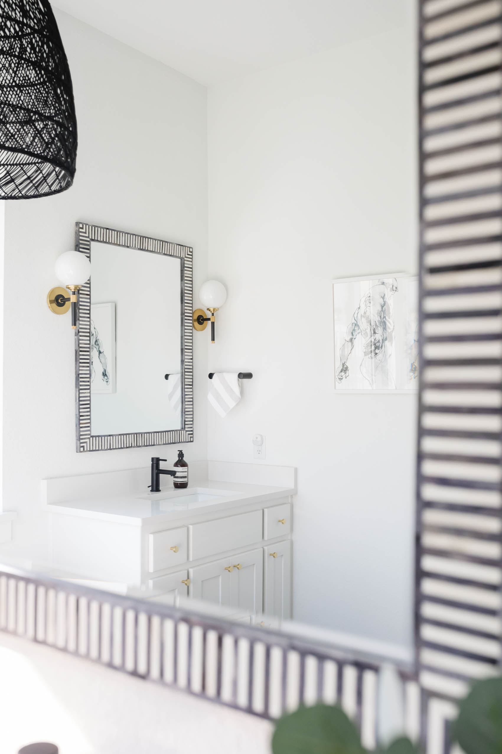White transitional bathroom with luxury bathroom accessories like Serena & Lily bar harbor mirrors in fog, Hudson Valley Bowery Sconce and more.