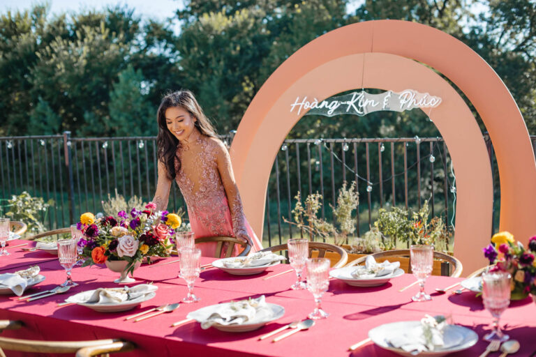 Blogger Hoang-Kim setting the table at her Dam Hoi, a Vietnamese Engagement Party, also known as Le Dinh Hon with rentals from Posh Couture and The Styled Affair wearing an ao dai by Thai Nguyen Atelier