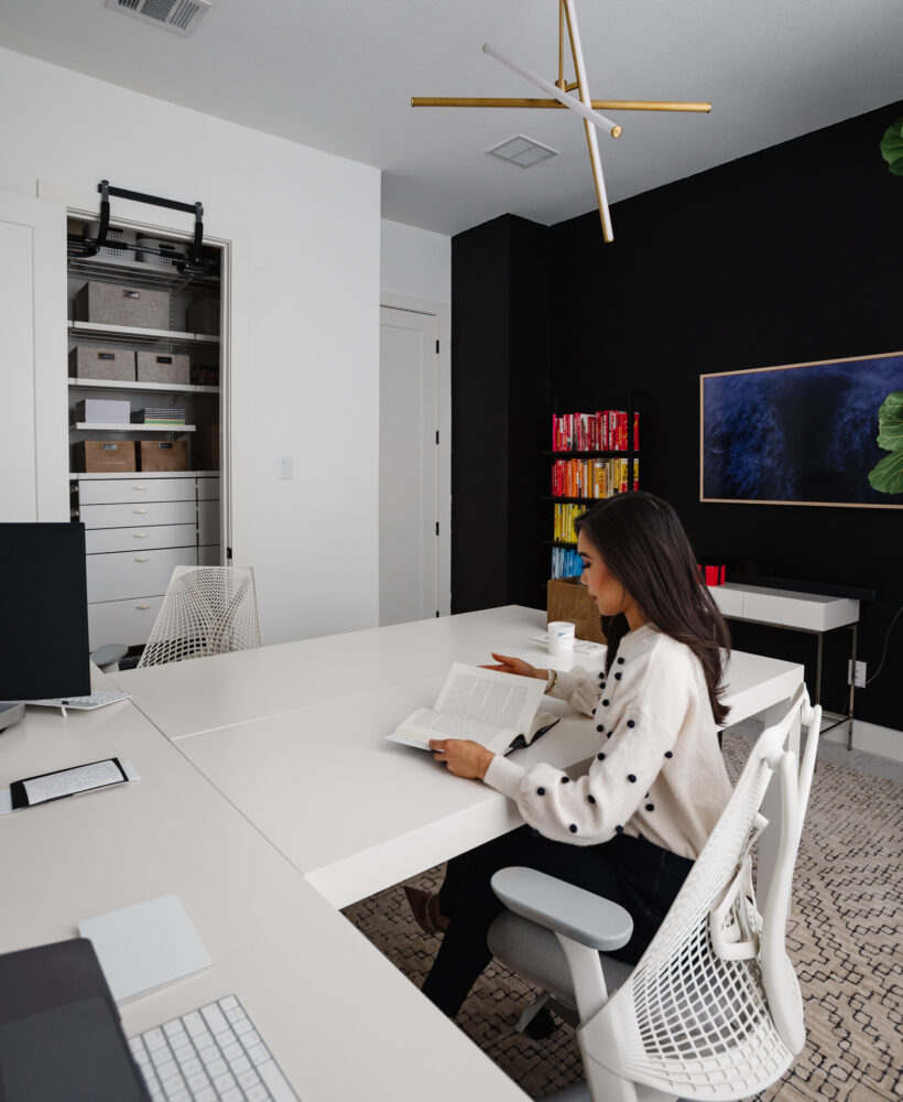 Blogger Hoang-Kim Cung discusses shared home office ideas in her transitional office including west elm parsons l-shaped desks, rainbow bookshelves, and a black statement wall