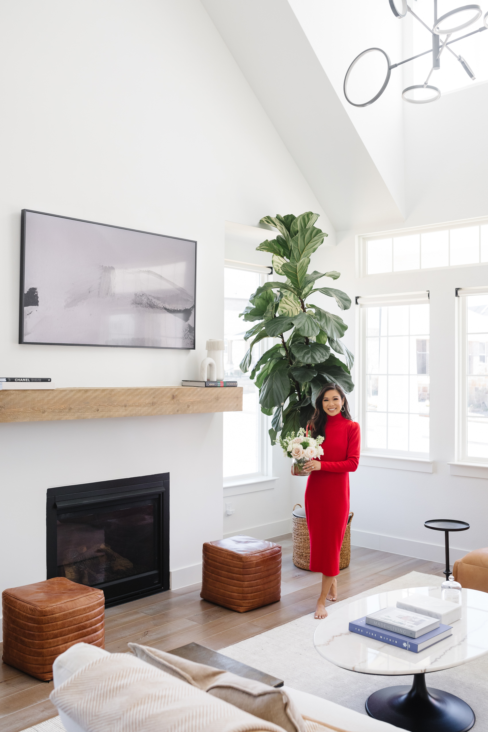 Blogger Hoang-Kim Cung's living room in her transitional style home with a fiddle leaf fig, Samsung Frame TV, Arhaus leather poufs, and Arhaus marble coffee table