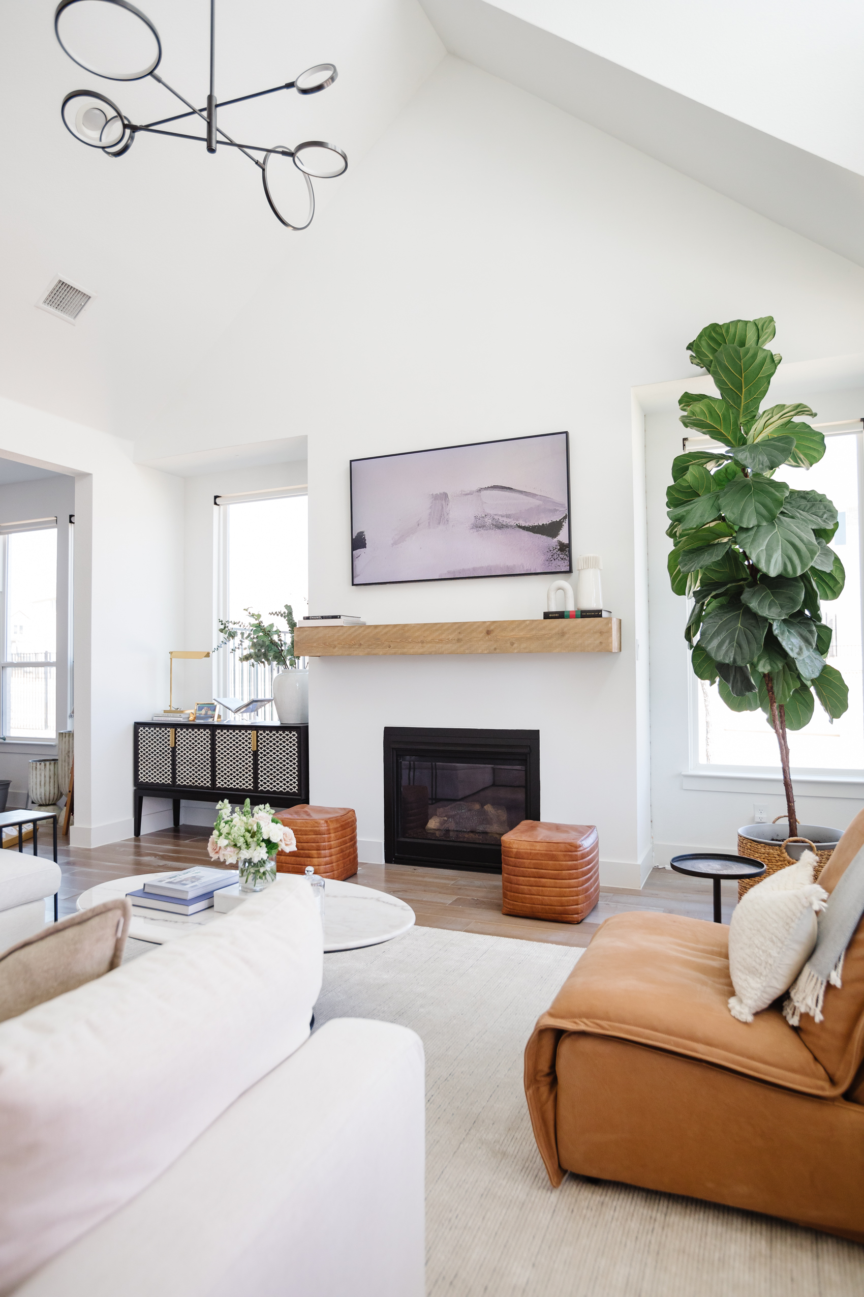 Blogger Hoang-Kim Cung's living room in her transitional style home with a Samsung Frame TV, fiddle leaf fig, Arhaus leather poufs, Arhaus leather recliner, and Arhaus bar cabinet