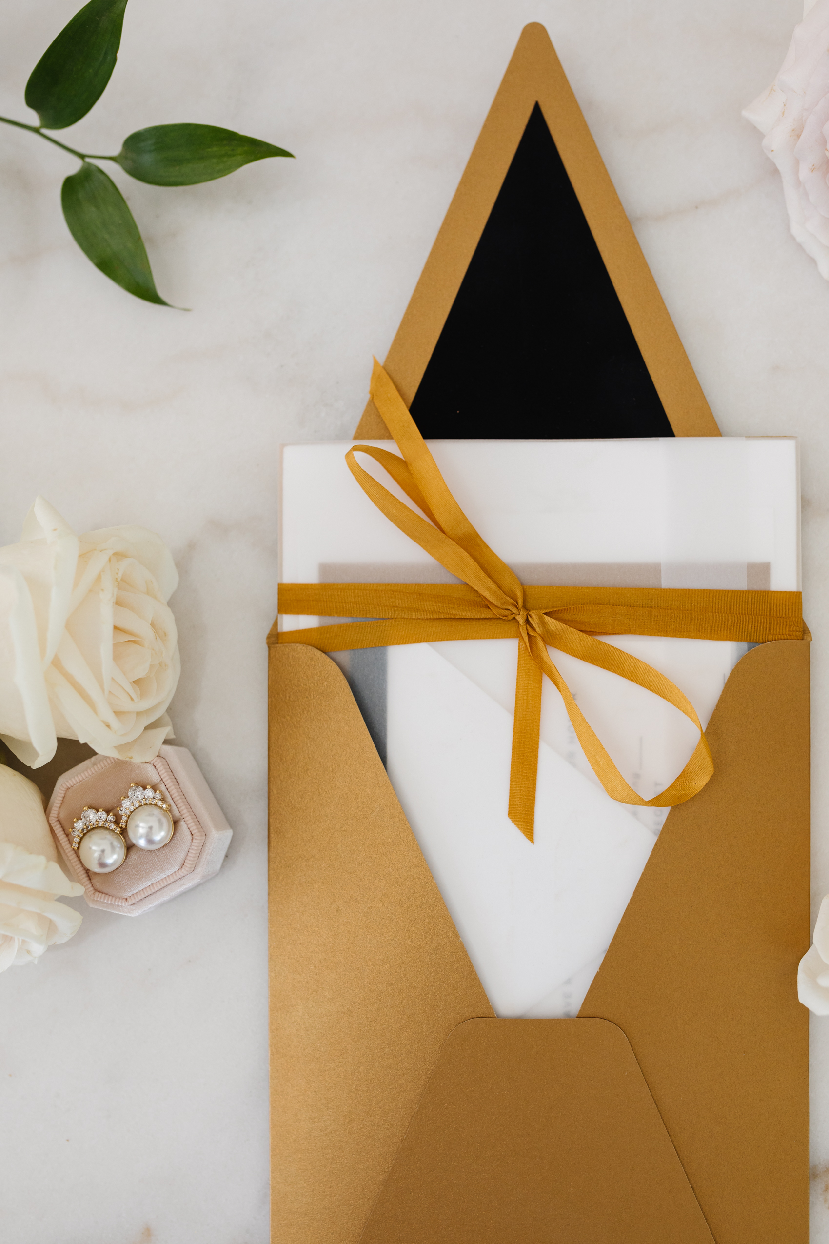 Blogger Hoang-Kim Cung's custom wedding invitations with gold envelopes, gold ribbon, and black envelope liners