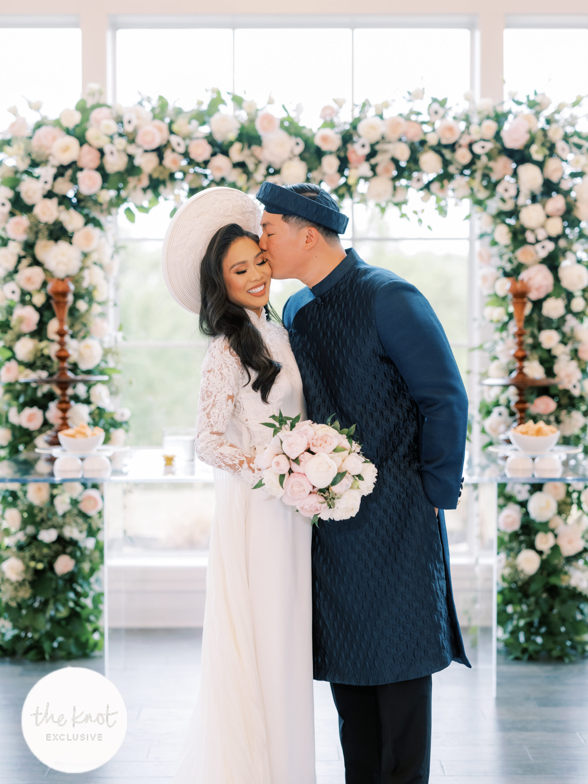 Hoang-Kim Cung and her husband, Jonathan Van on their wedding day wearing Thai Nguyen Atelier wedding ao dai at the Hillside Estate with floral arch and pink peonies bouquet