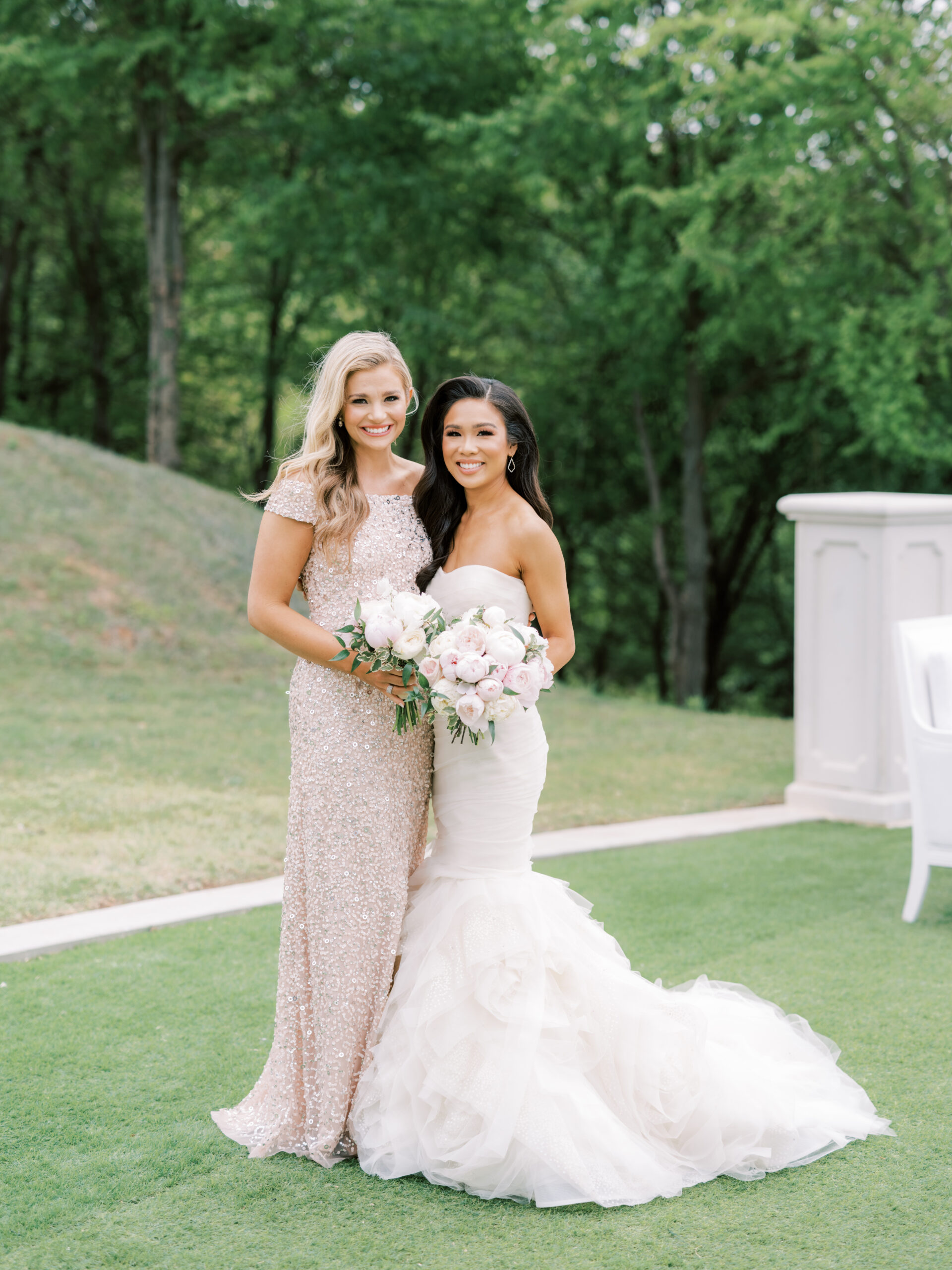 Hoang-Kim wearing a Vera Wang Gemma mermaid gown with her bridesmaid, Danielle Doty Fitzgerald wearing an Adriana Papell off-the-shoulder gown and olive + piper earrings