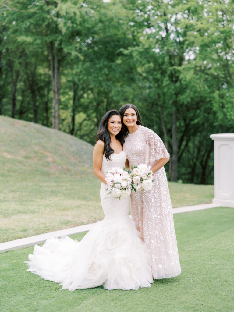 Hoang-Kim Cung wearing a Vera Wang Gemma gown with her Maid of Honor wearing a Needle & Thread Sequin Ribbon gown at a Dallas outdoor wedding with a lush peony bouquet