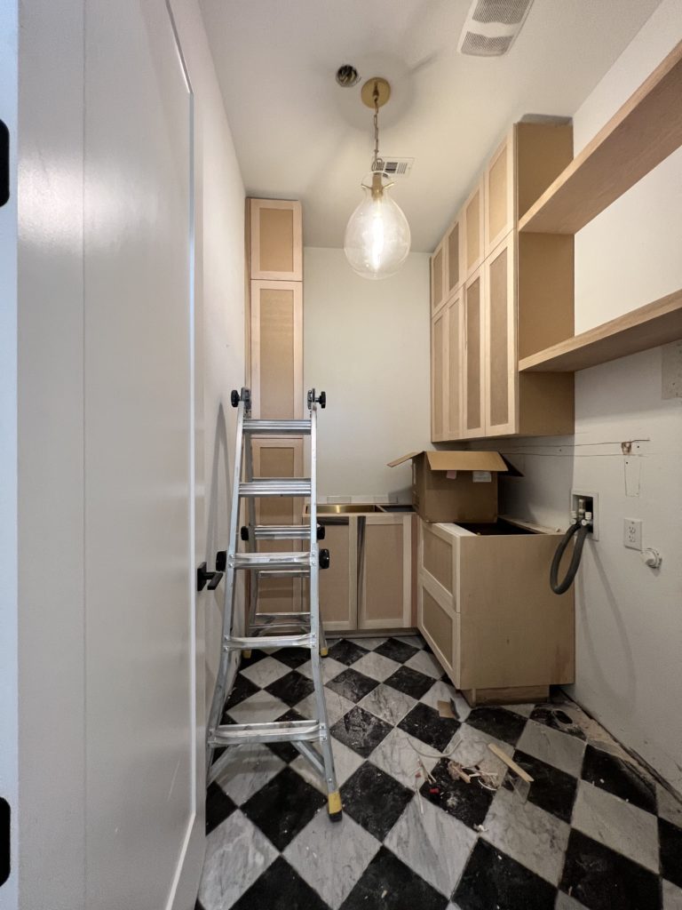 Laundry room progress with Alexander James Tile Studio french antique marble checkerboard floors and custom cabinets.