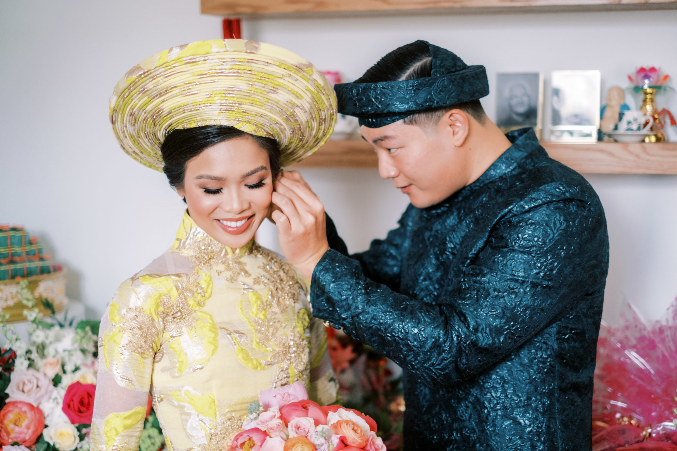 Jonathan Van puts earrings on his bride, Hoang-Kim Cung during their Vietnamese Wedding Ceremony.