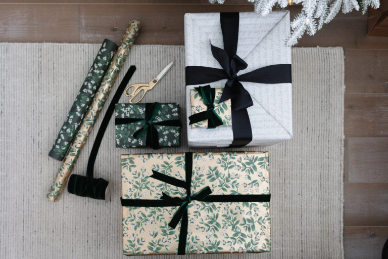 blogger hoang-kim cung shares how to wrap a gift with evergreen mistletoe wrapping sheets by rifle paper co, mistletoe gold wrapping sheets by rifle paper co, and oh christmas tree gift wrap by sugar paper + target