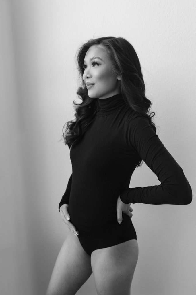 Blogger Hoang-Kim at 20 weeks pregnant wearing a black maternity bodysuit.