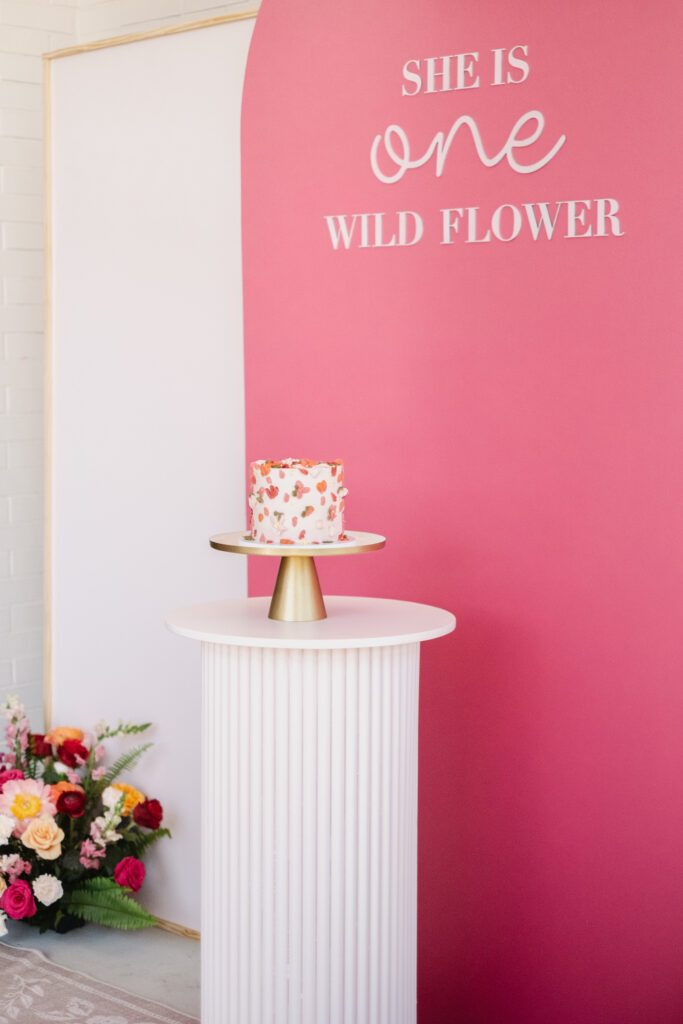 Palette knife cake for a floral first birthday party with Glo Party Co backdrop