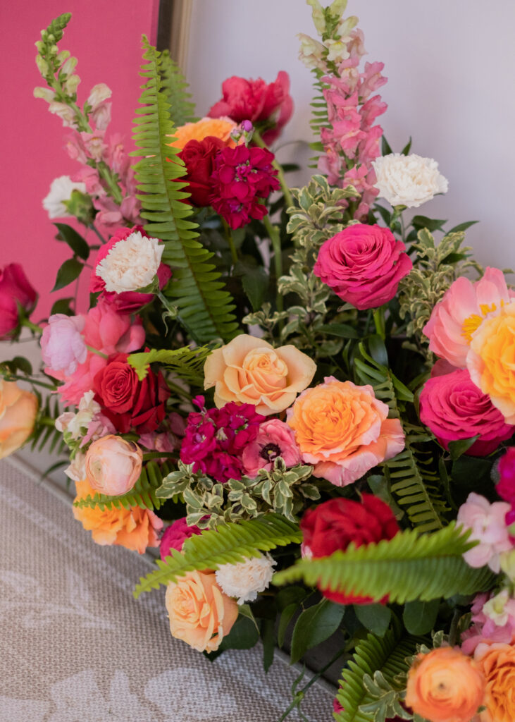 Bright pink roses, orange roses, spray flowers and light pink carnations from Something Pretty Floral