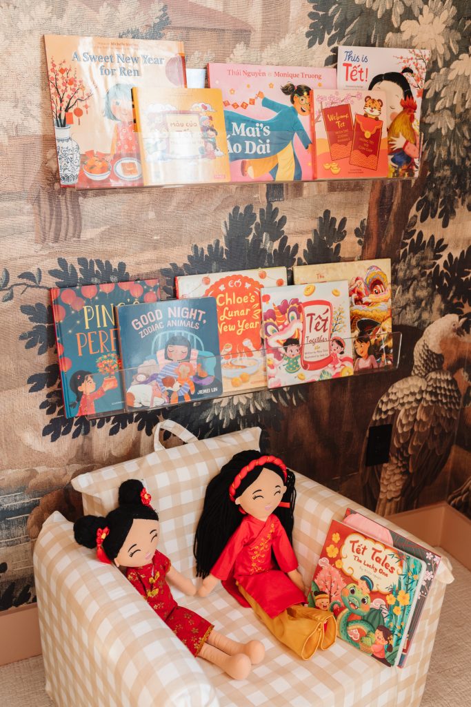 Lunar New Year Books celebrating Tet, Vietnamese New Year and Chinese New Year on clear bookshelves in a toddler's room with JoeyDolls Asian Cultural Dolls and a Nestig mini chair.